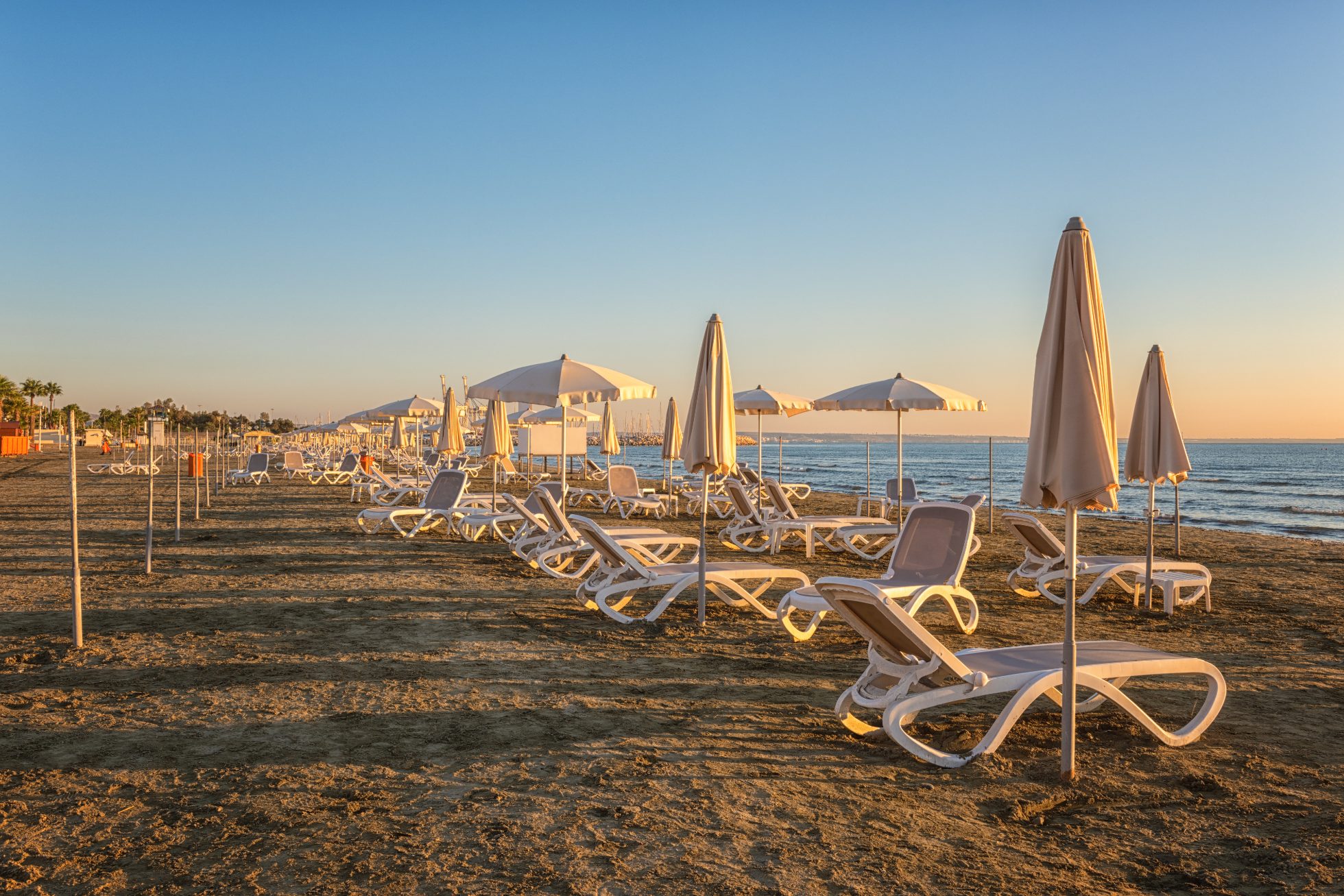 Widok piaszczystej plaży w Larnace o wschodzie słońca, kurort turystyczny, Cypr.