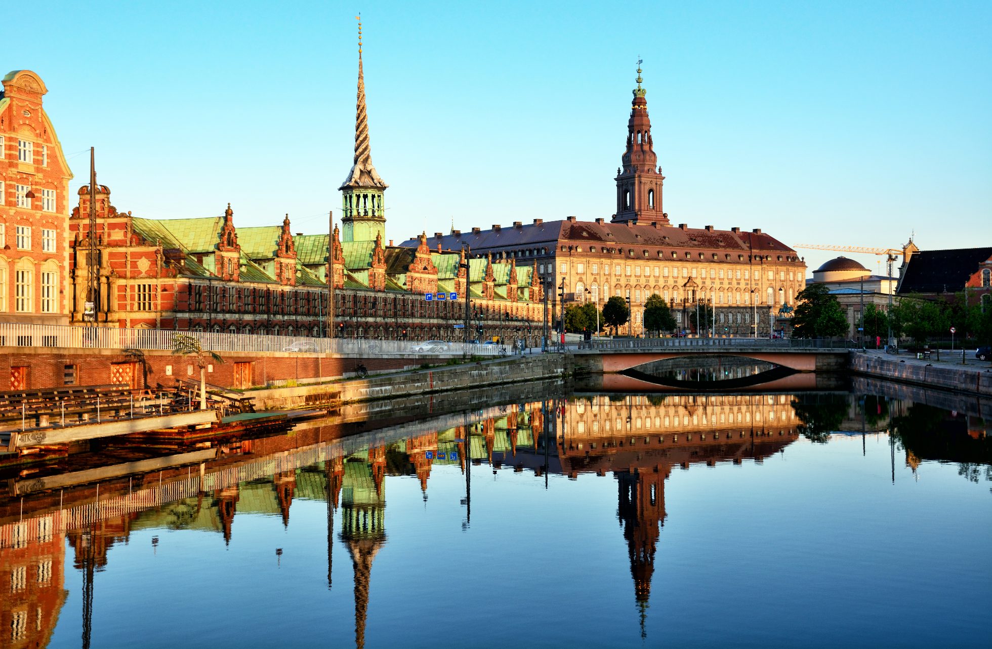 Pałac Christianborg w Kopenhadze, duży budynek z charakterystyczną kopułą, otoczony zielenią.