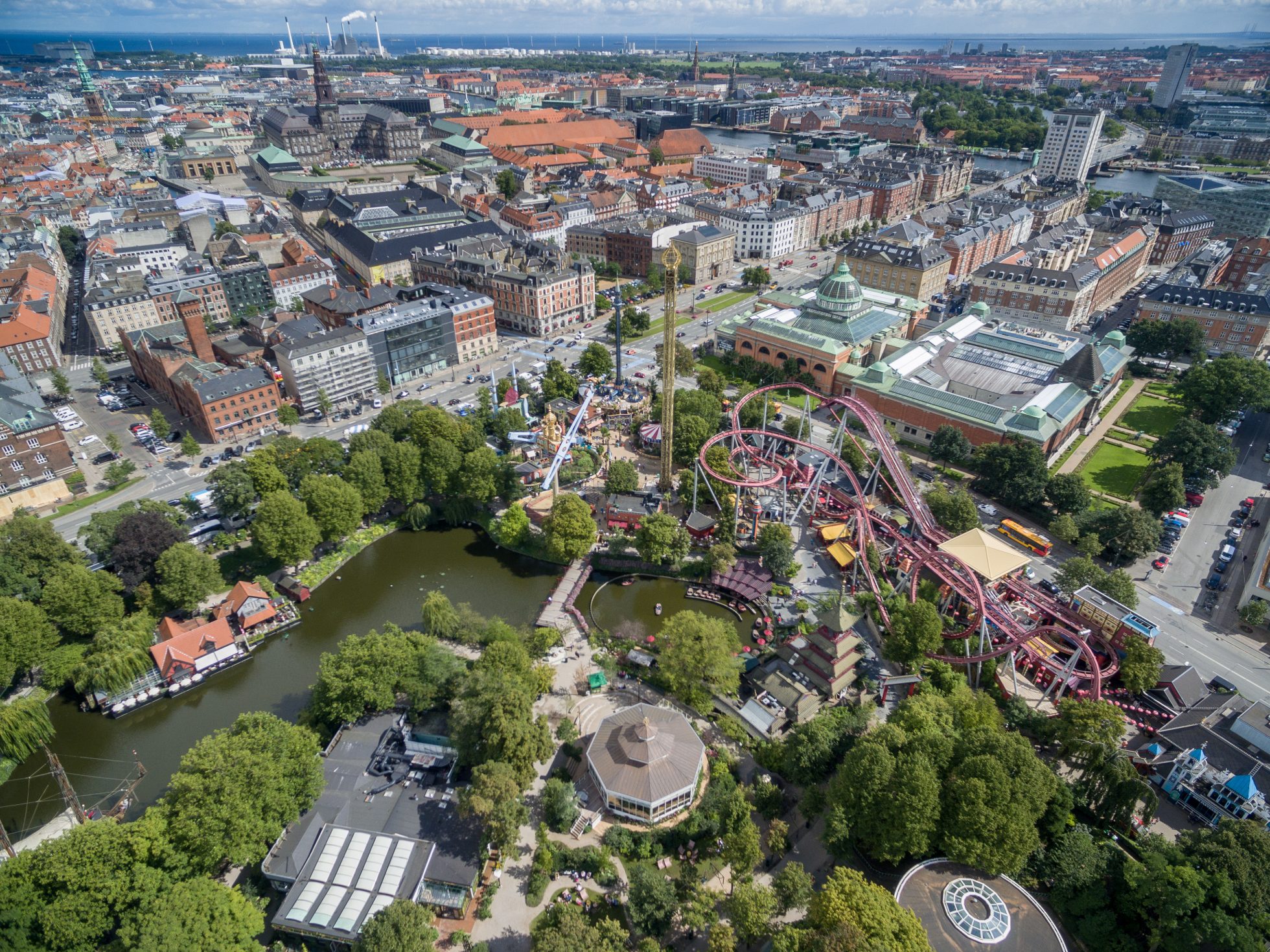 Park Tivoli w Kopenhadze z widocznymi kolorowymi latarniami i roślinnością.