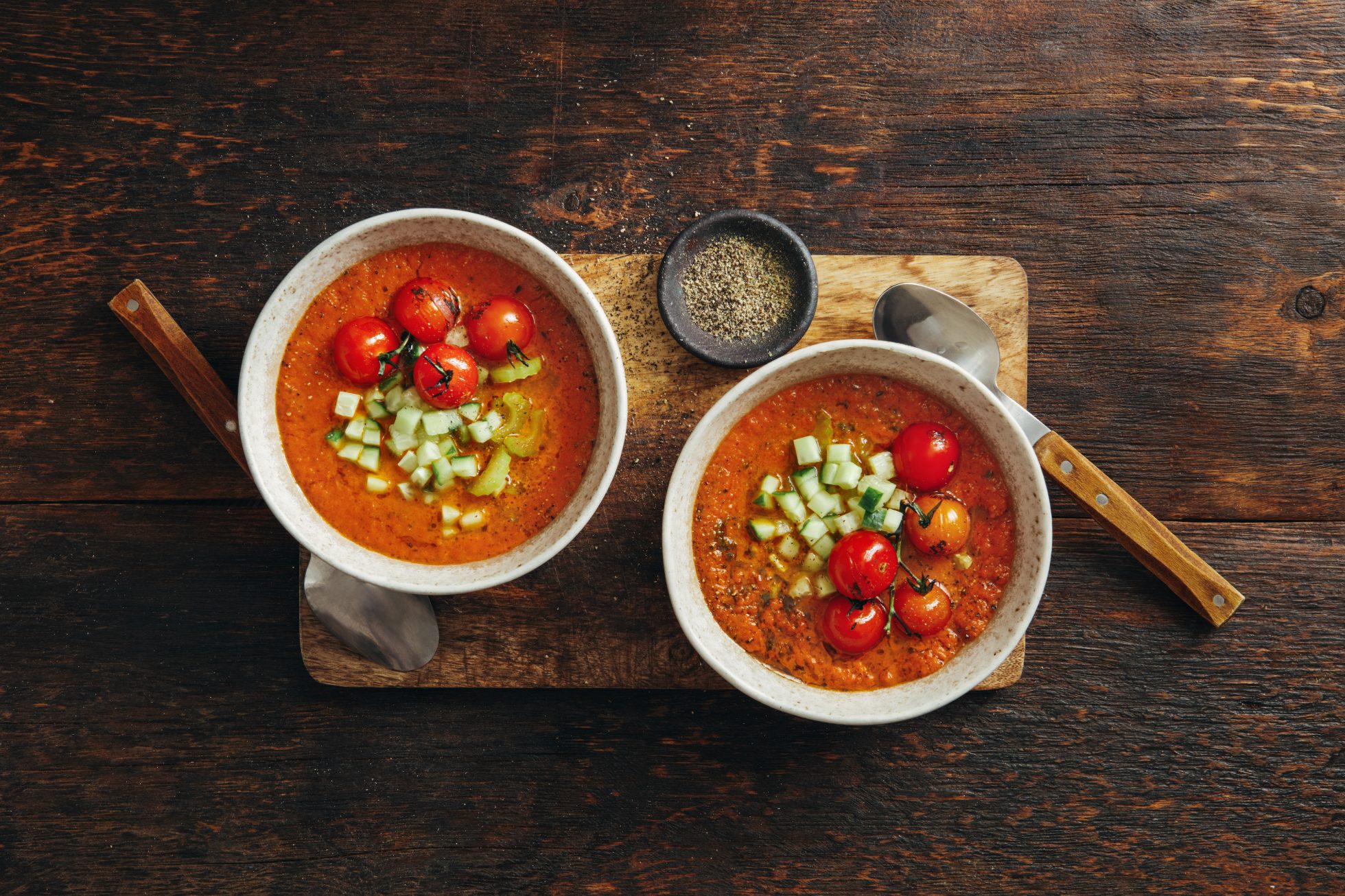 Autentyczne gazpacho. Hiszpańska zimna zupa pomidorowa. Ujęcie z góry na ciemnym drewnianym tle. Zdjęcie w formacie poziomym z miejscem na tekst.