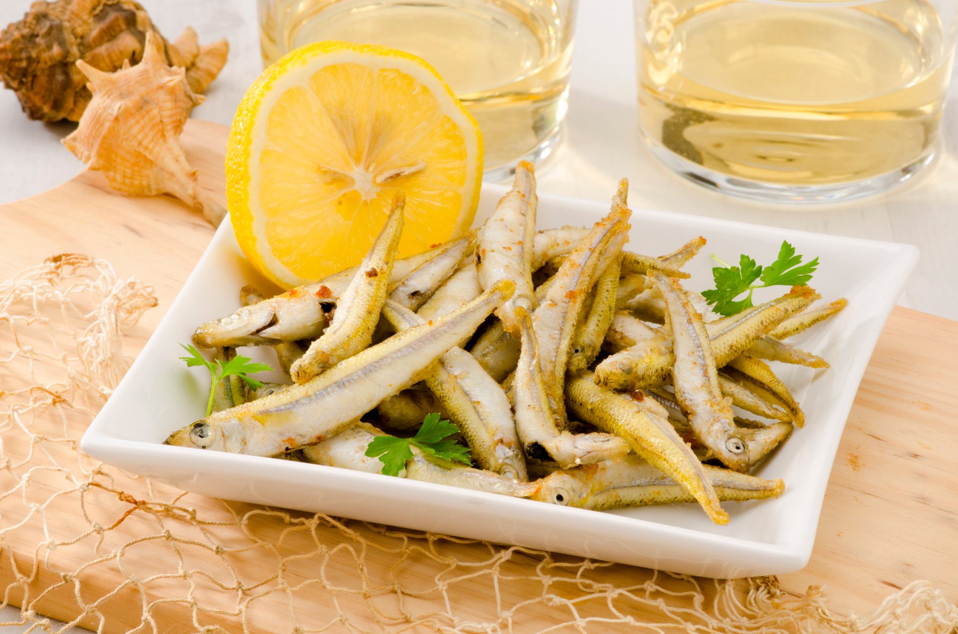 Kuchnia hiszpańska. Tapas. Smażone owoce morza na białym talerzu. Selektywna ostrość. Pescaito frito.