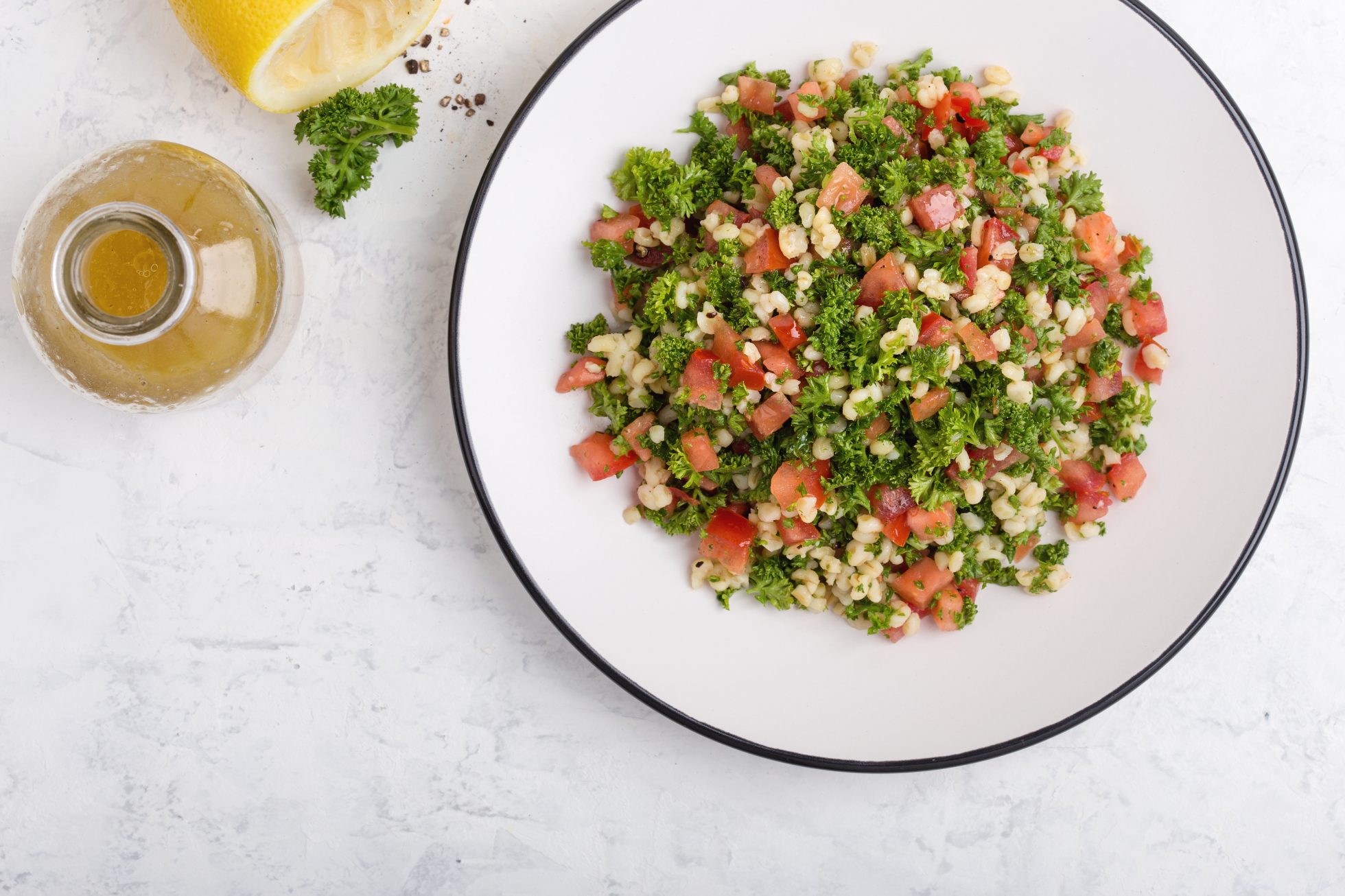 Sałatka tabbouleh z kaszą bulgur, świeżą pietruszką, pomidorami i sosem sałatkowym.