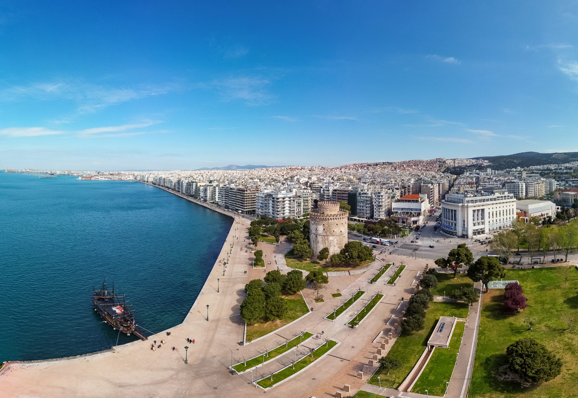 Plaża Nea Paralia w Salonikach. Widok na morze, plażę i promenadę z palmami.