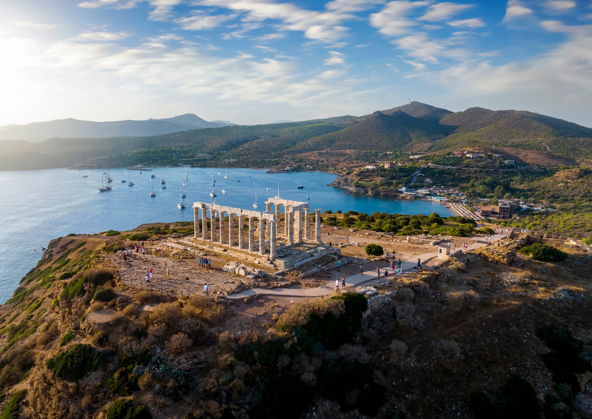 Widok z lotu ptaka na plażę i świątynię Posejdona w Cape Sounion na skraju Attyki w Grecji, podczas letniego zachodu słońca, Ateny plaże