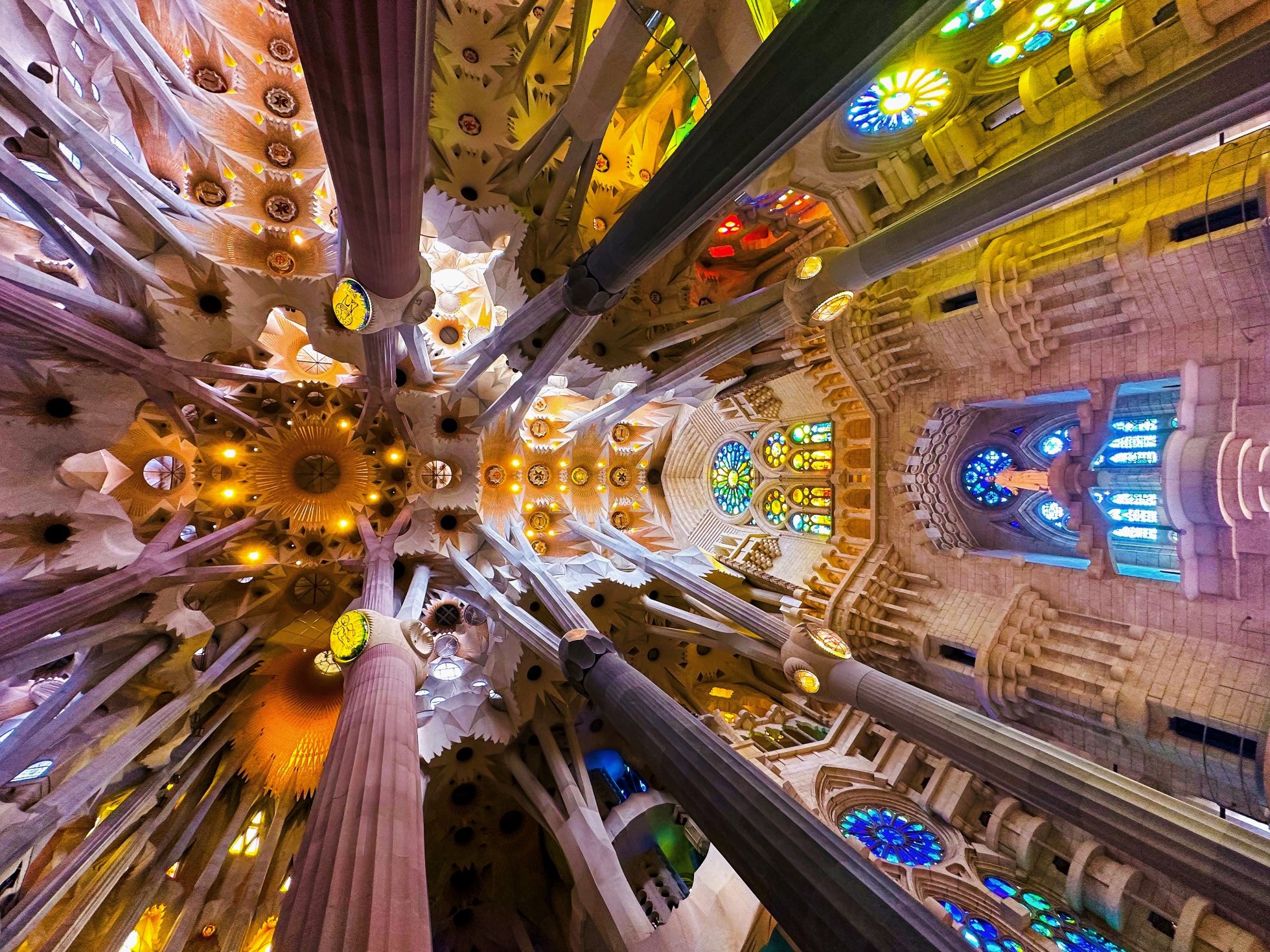 the vault of the Sagrada Familia Cathedral in Barcelona with colorful stained glass windows
