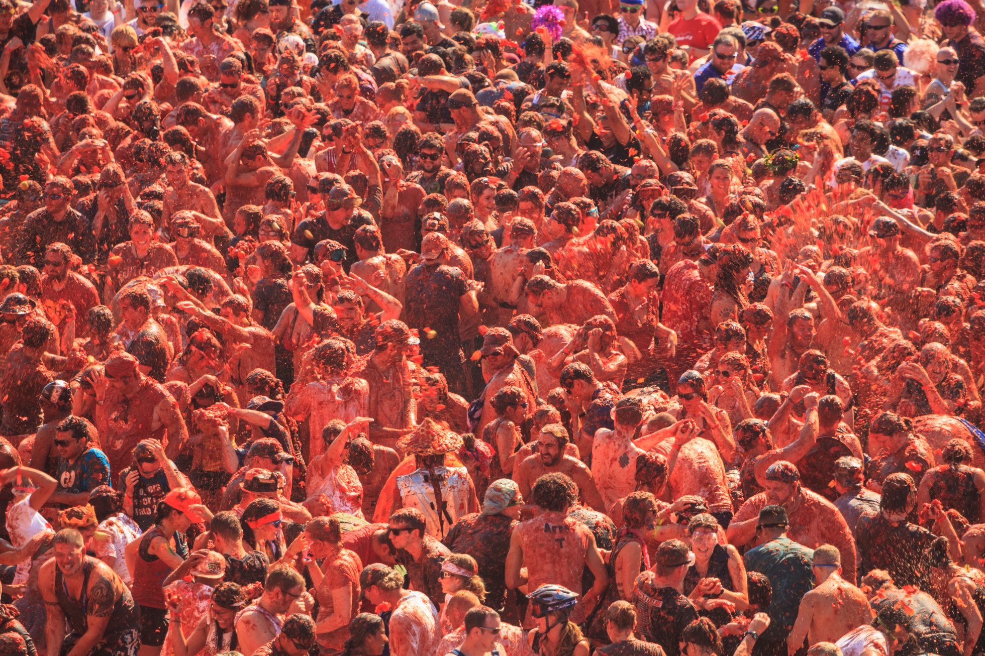 Tłum ludzi bawi się w rzucanie pomidorami podczas festiwalu La Tomatina w Hiszpanii.