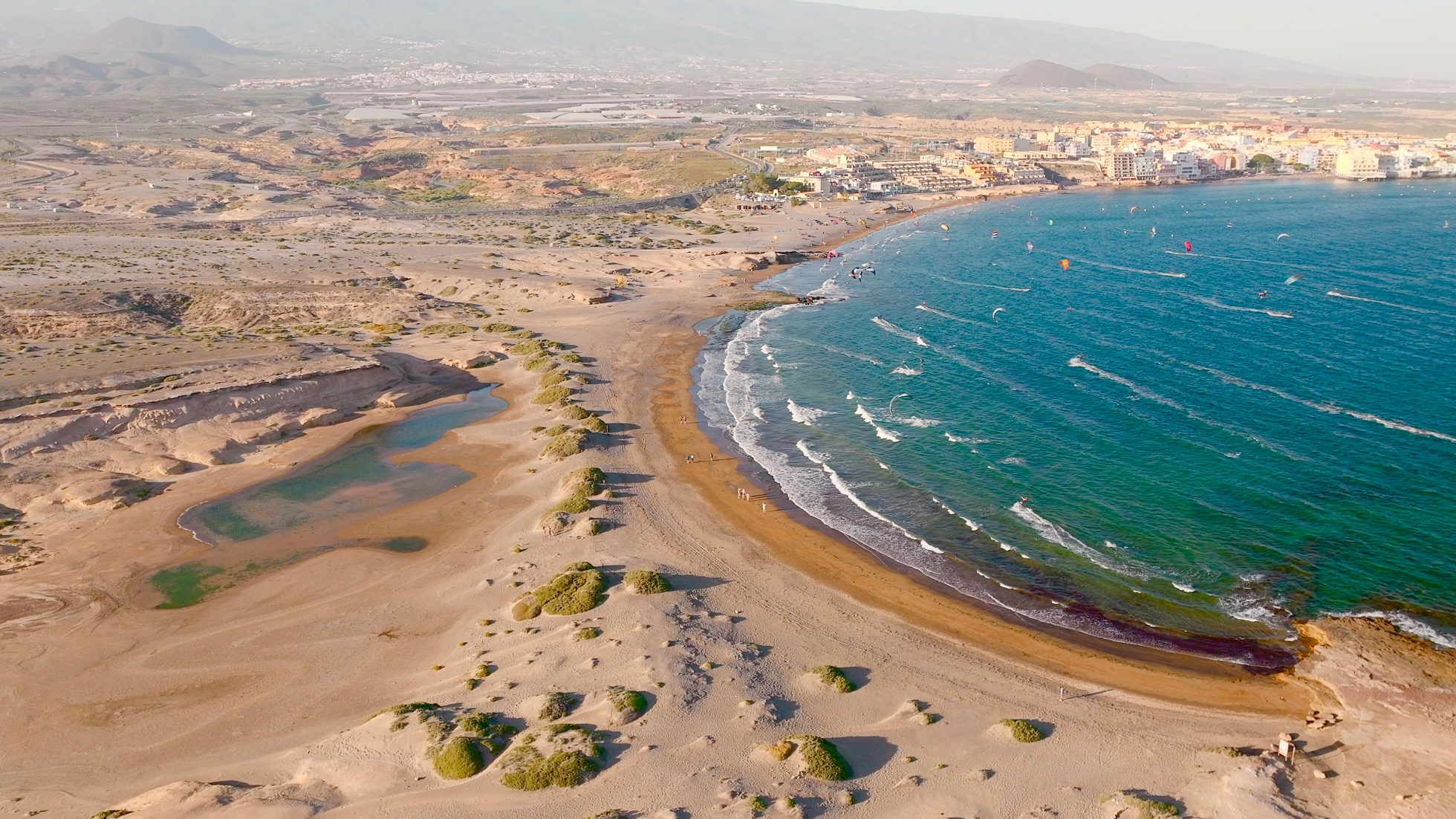 Plaża El Medano na Teneryfie z widokiem na ocean i niebieskie niebo.