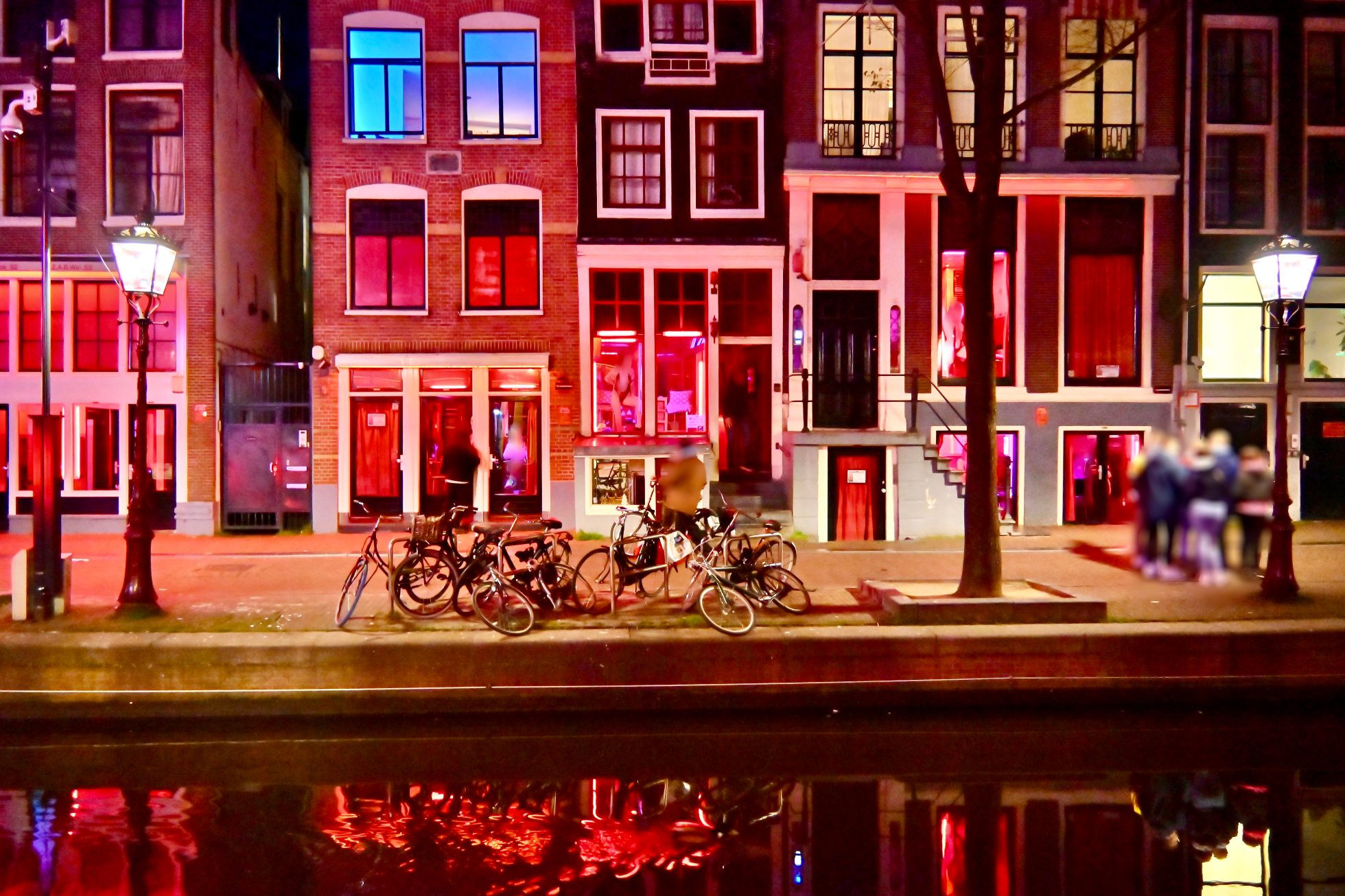 Ciemna ulica z czerwonymi latarniami w Amsterdamie.