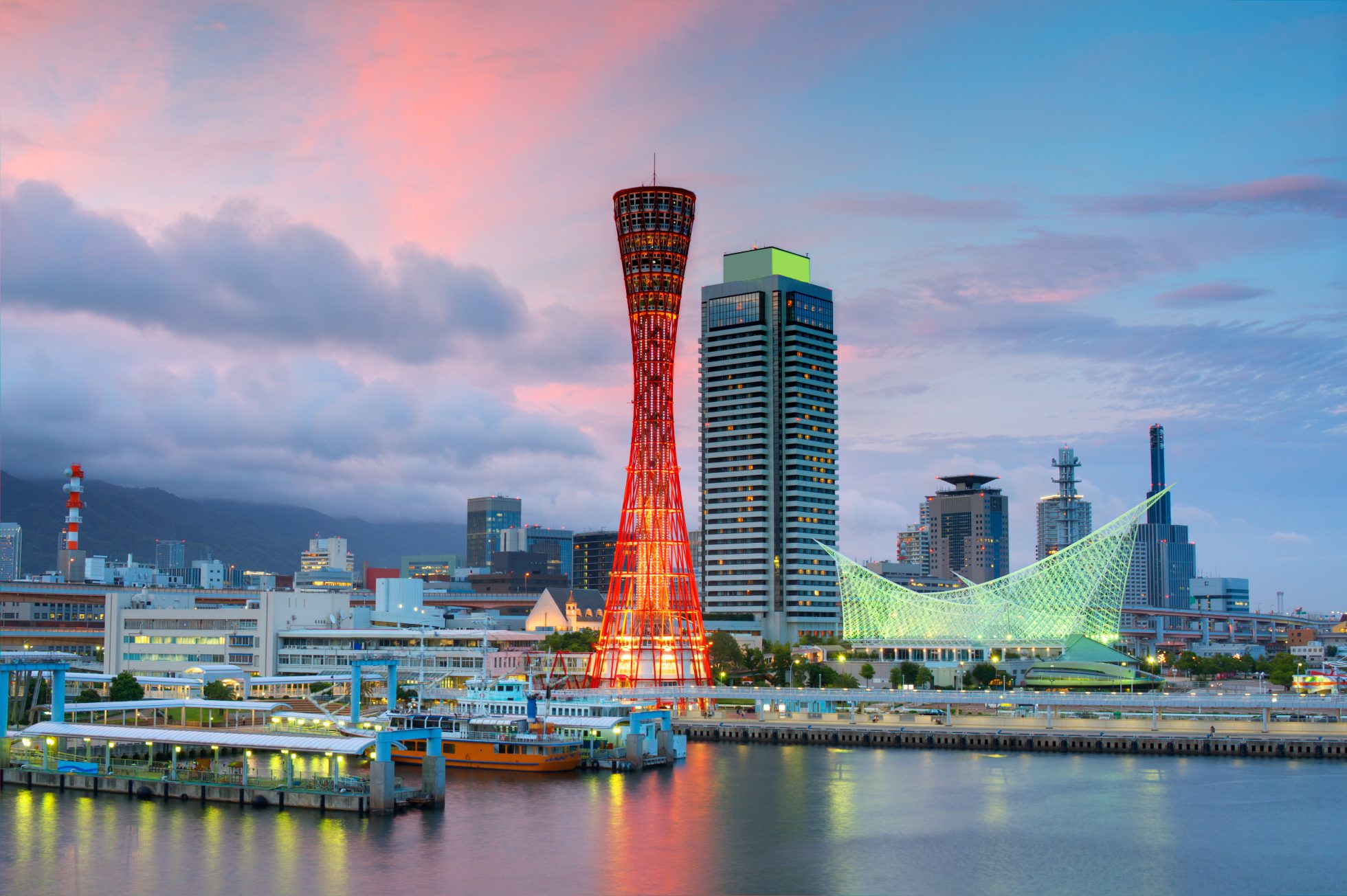 Wieża Kobe w kolorze czerwonym (futurystyczna architektura) i rozświetlone miasto w tle