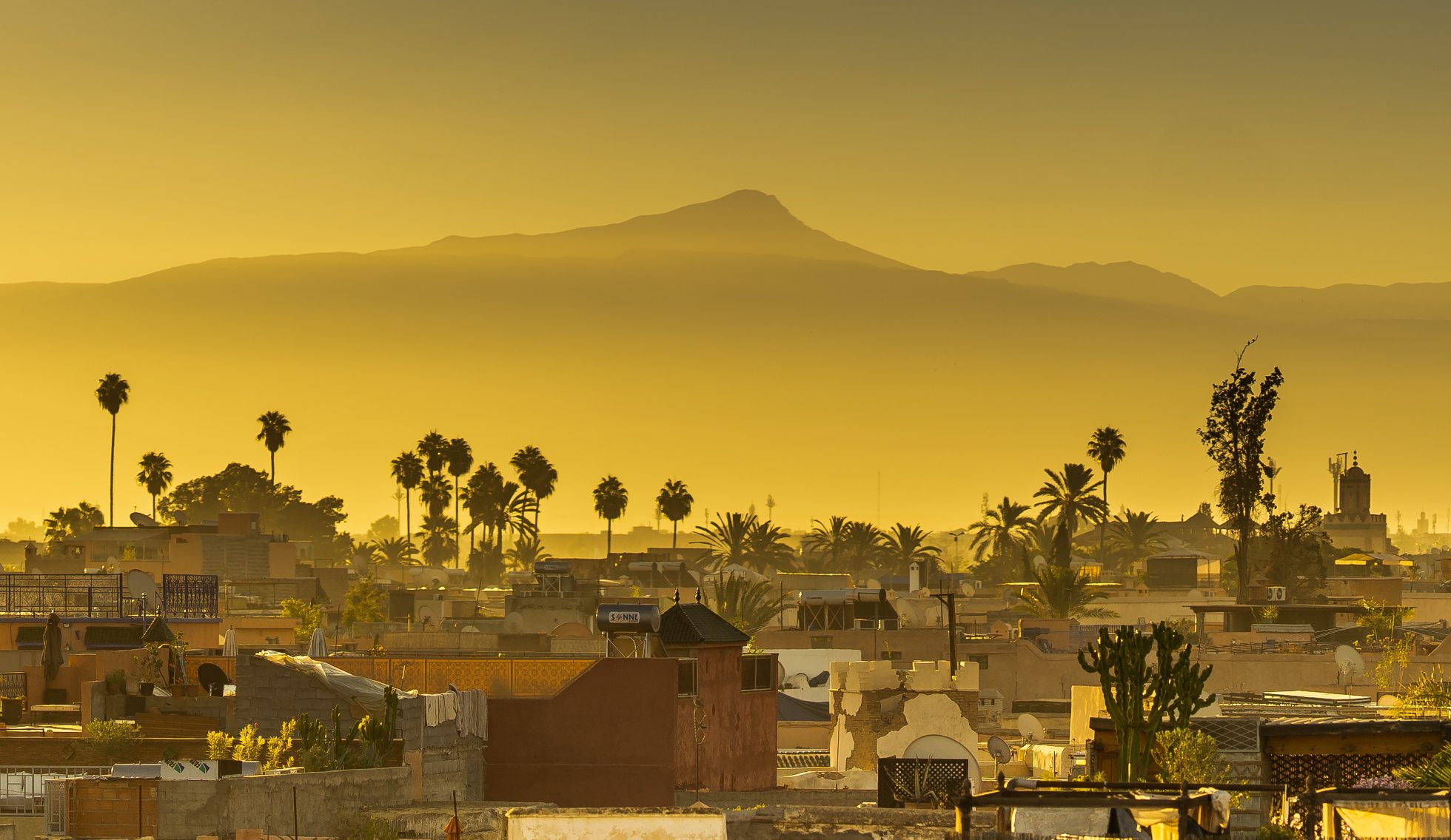 Piękny widok na dachy Marrakeszu i góry Atlas podczas wschodu słońca