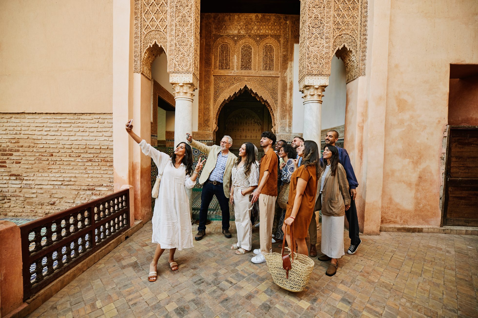 Szerokie ujęcie grupy podróżników robiących selfie przy grobowcach Saadytów, kultowym zabytku Marrakeszu