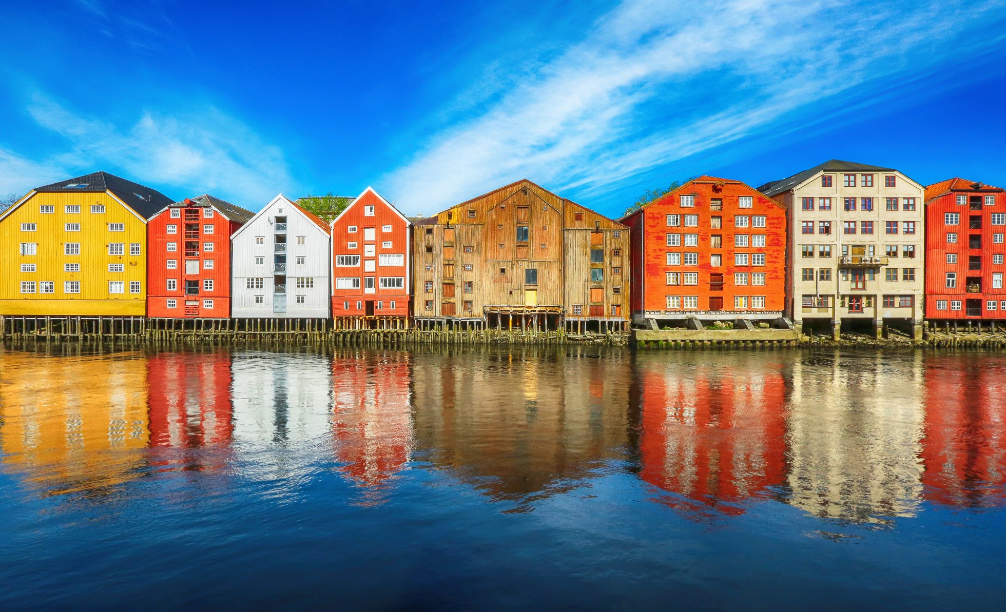 Stare drewniane budynki położone wzdłuż rzeki Nidelva w historycznym centrum Trondheim, Norwegia.