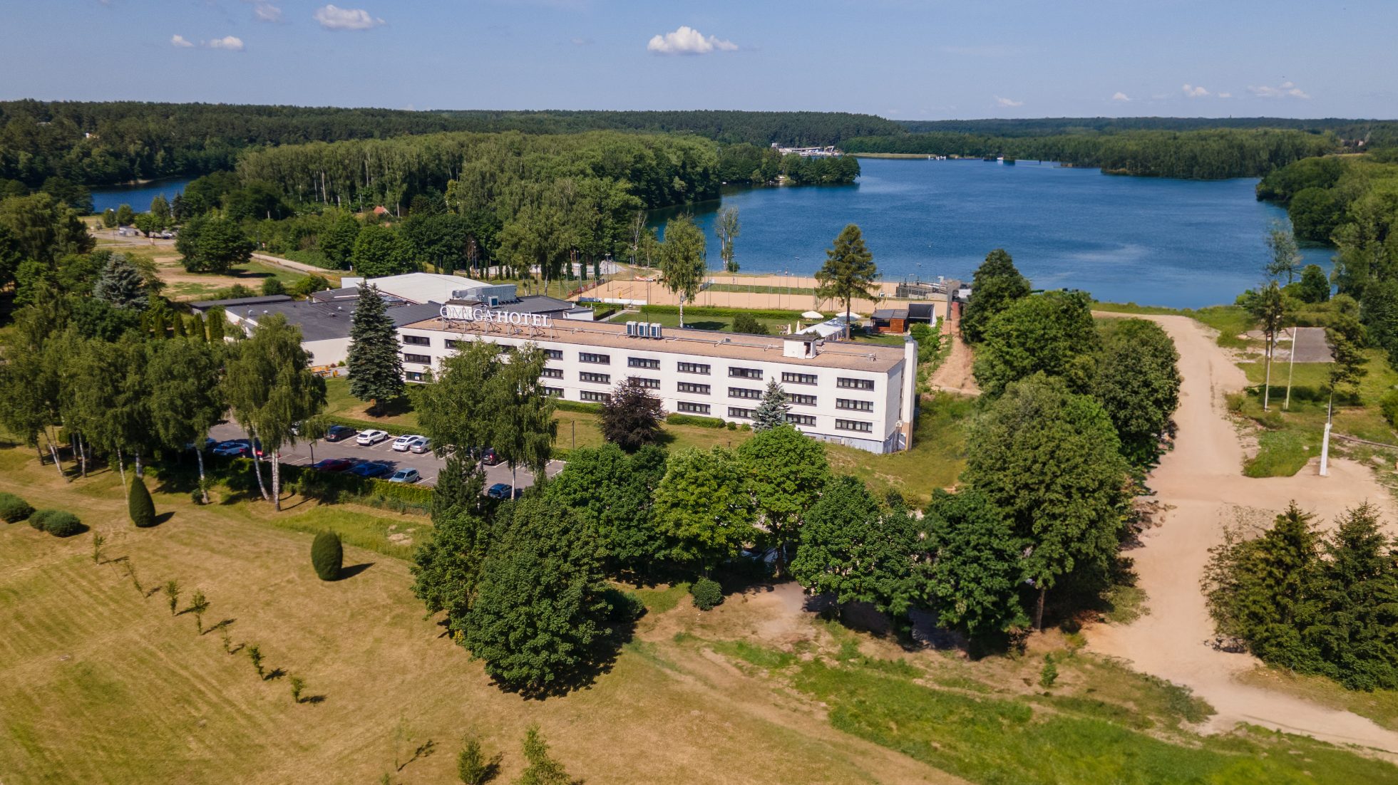 Budynek hotelu z zielonymi drzewami i niebieskim niebem w tle.