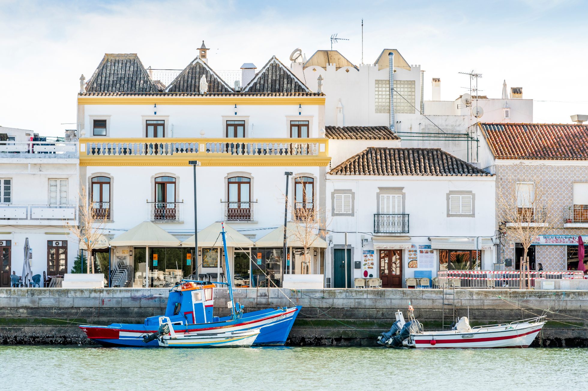 Plaża w Tavira, Portugalia. Błękitne morze, złoty piasek i niebo bez chmur.