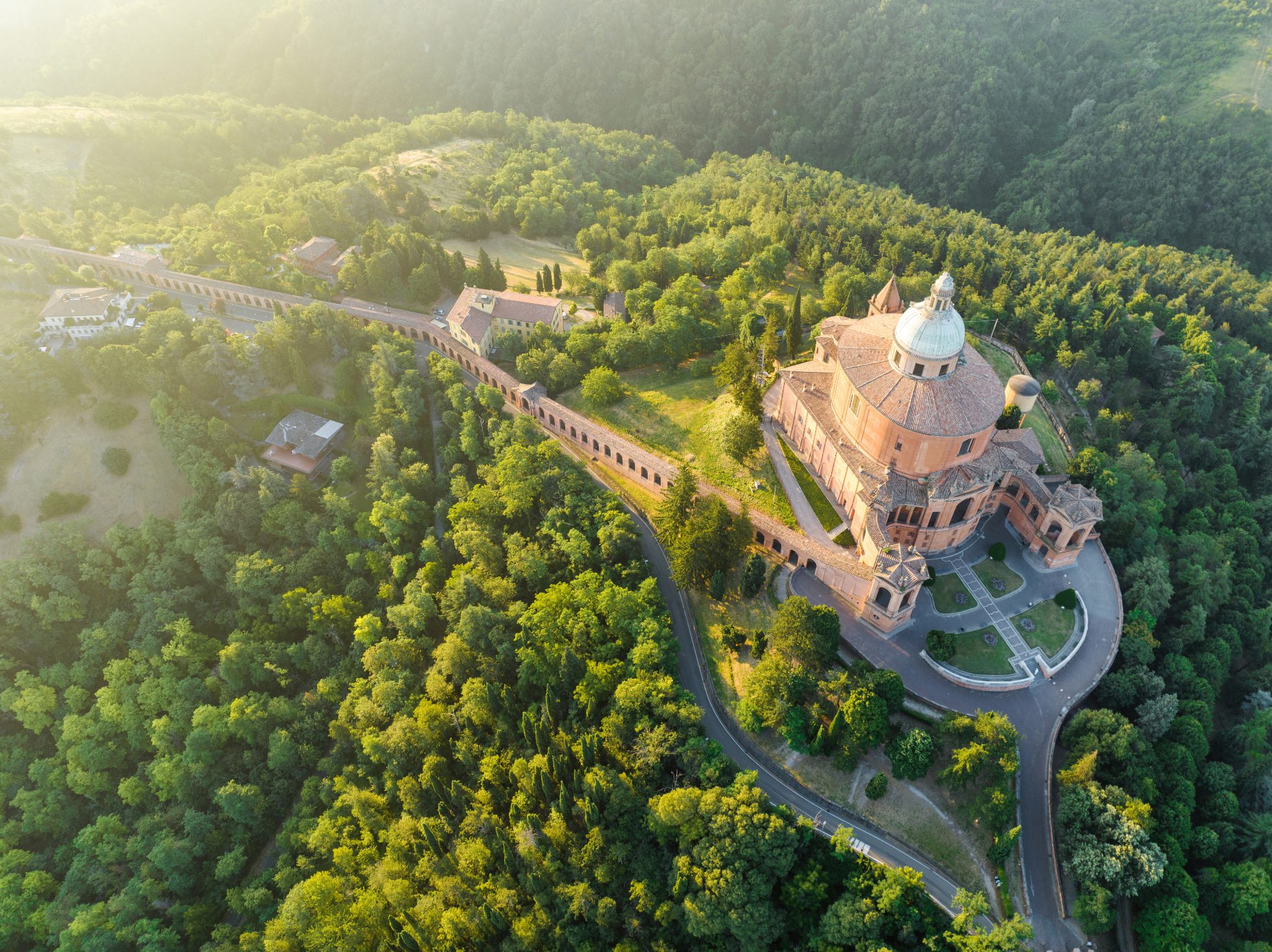 Aerial Drone Sunrise Scene of Sanctuary of the Madonna di San Luca chapel existed on the hill for about a thousand years with a road now leads up to the sanctuary, it along a 3.8 km monumental roofed arcade (Portico di San Luca) consisting of 666 arches