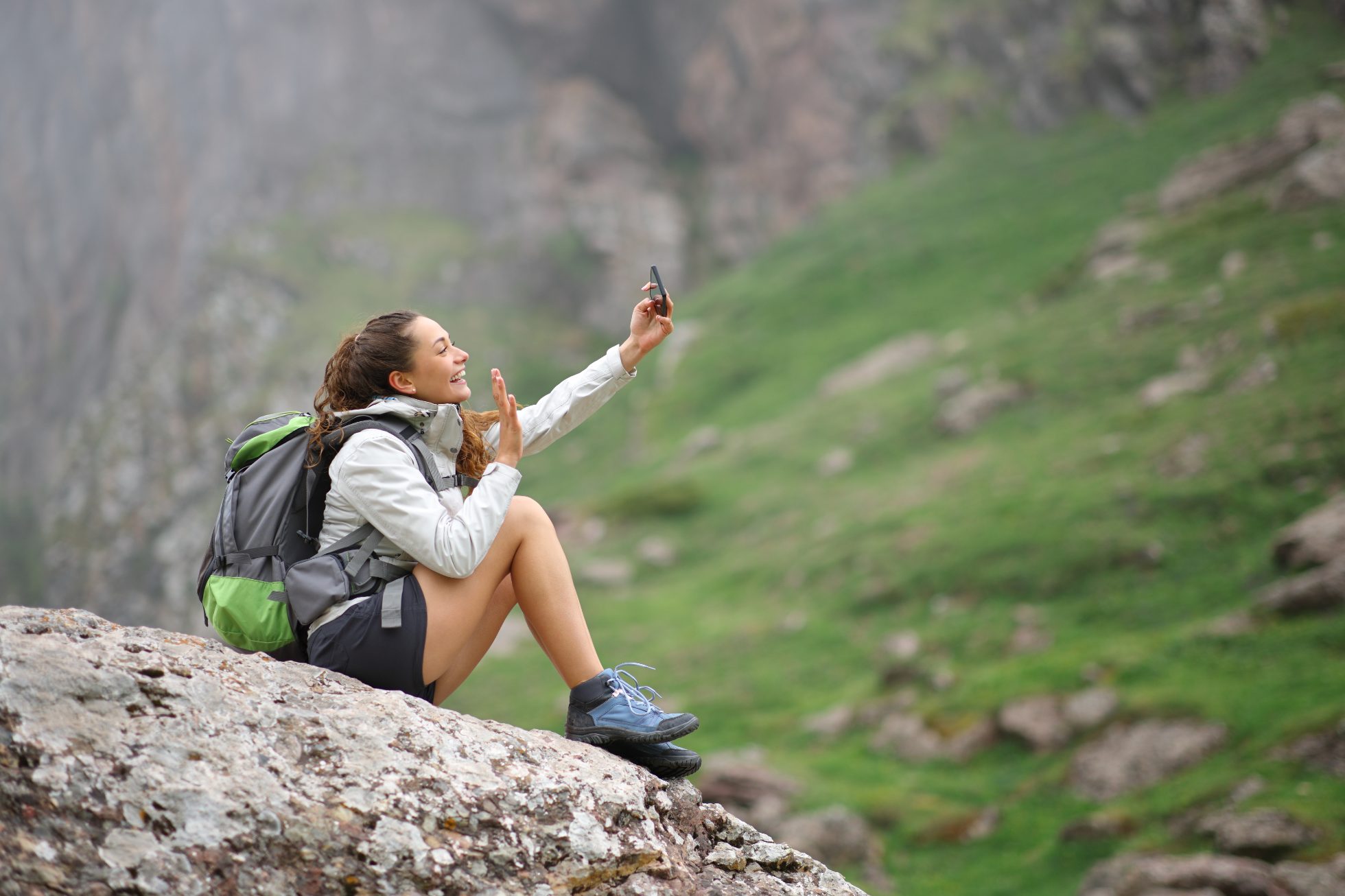Turysta robiący selfie na skale w górach, ekoturystyka
