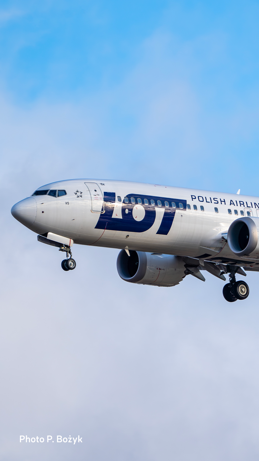 Passenger plane of LOT Polish Airlines against a sky with clouds.