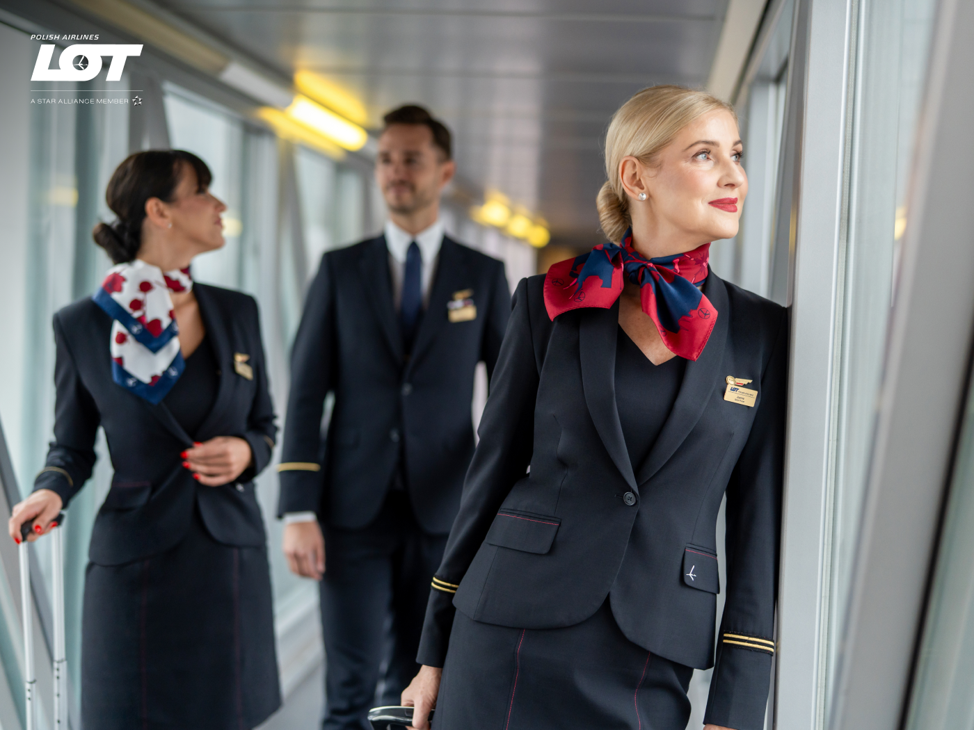 The flight crew walking through the tunnel to the airport wearing hollyhock scarves