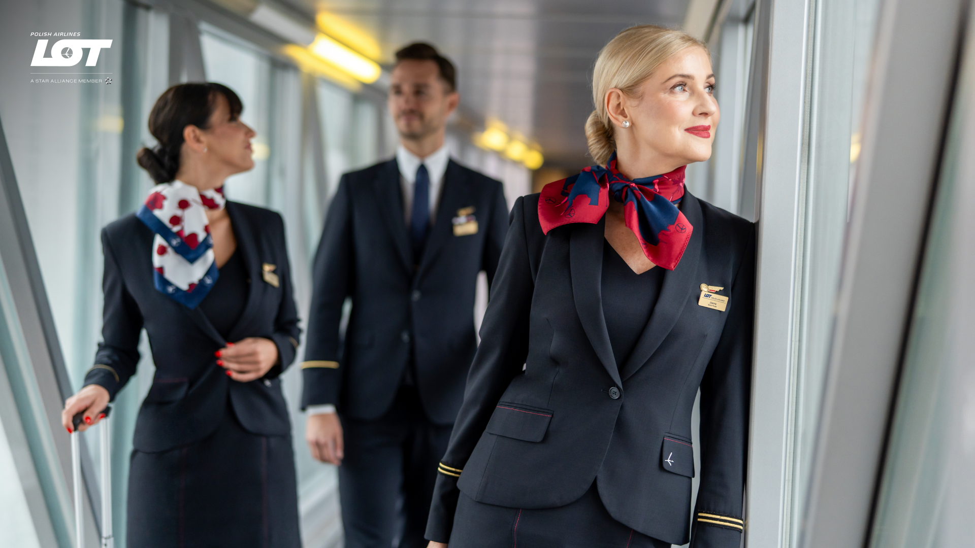 The flight crew walking through the tunnel to the airport wearing hollyhock scarves