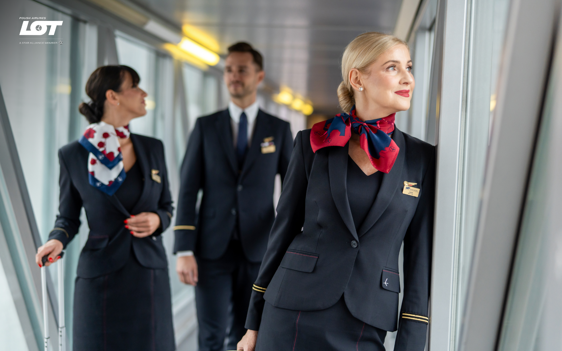 The flight crew walking through the tunnel to the airport wearing hollyhock scarves