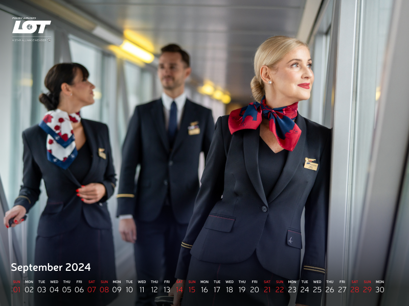 The flight crew walking through the tunnel to the airport wearing hollyhock scarves