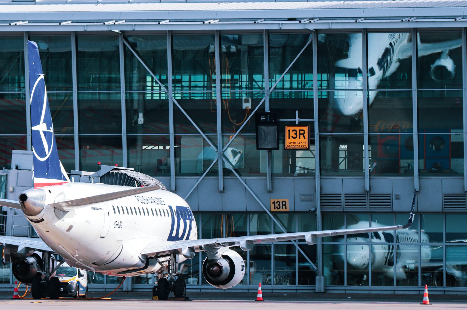 Embraer 170 standing by the gate at Chopin Airport; LOT for the environment