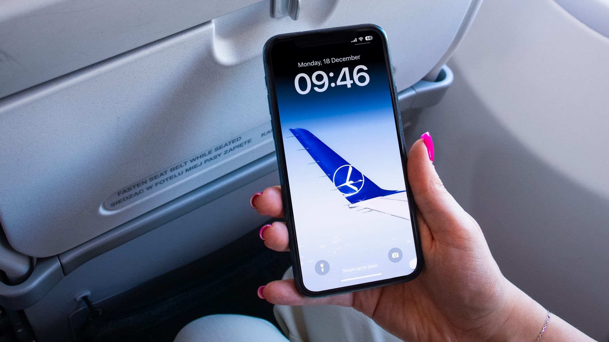 dłoń trzymająca telefon z tapetą lotu na telefon