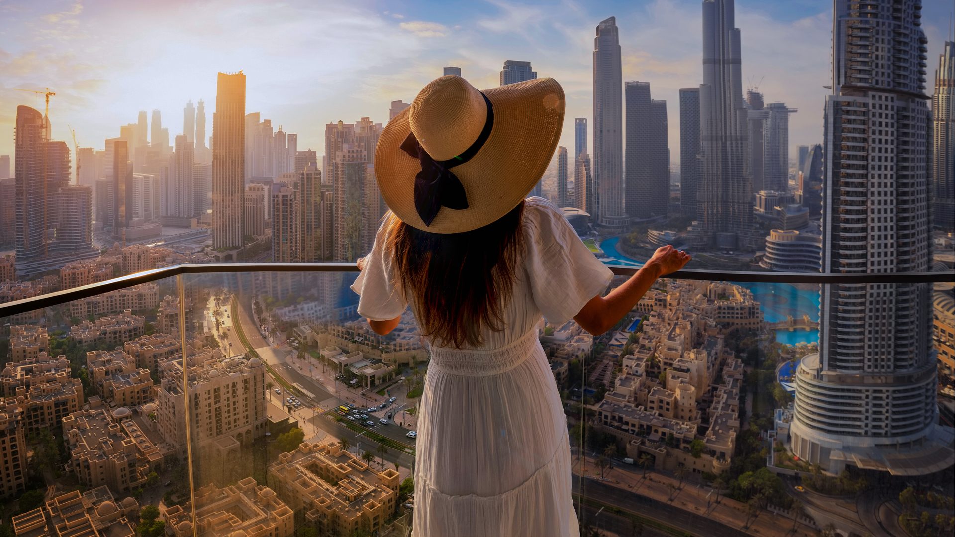 Kobieta stojąca na balkonie, a w tle panorama Dubaju