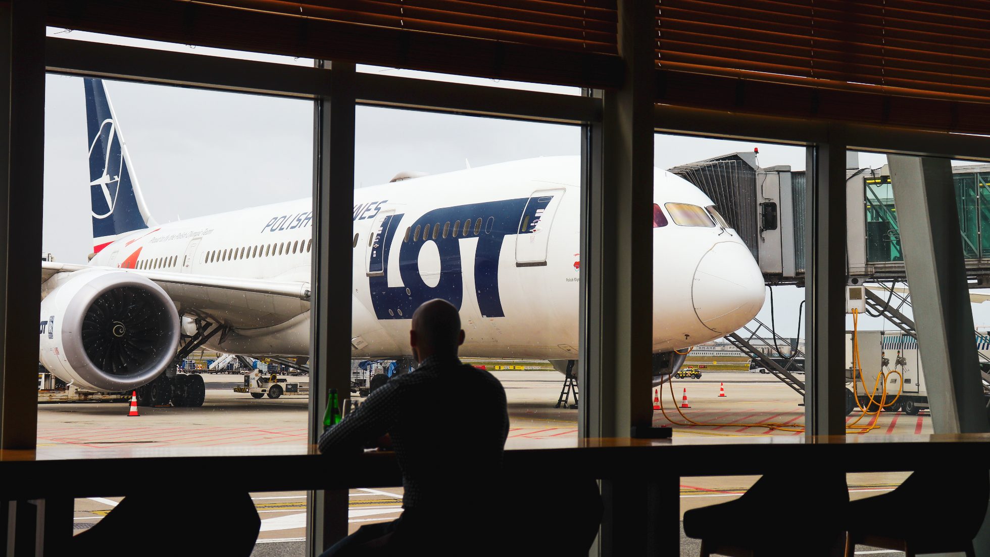 Panoramic windows overlooking the 787 Dreamliner standing on the tarmac - LOT Business Lounge Mazurek