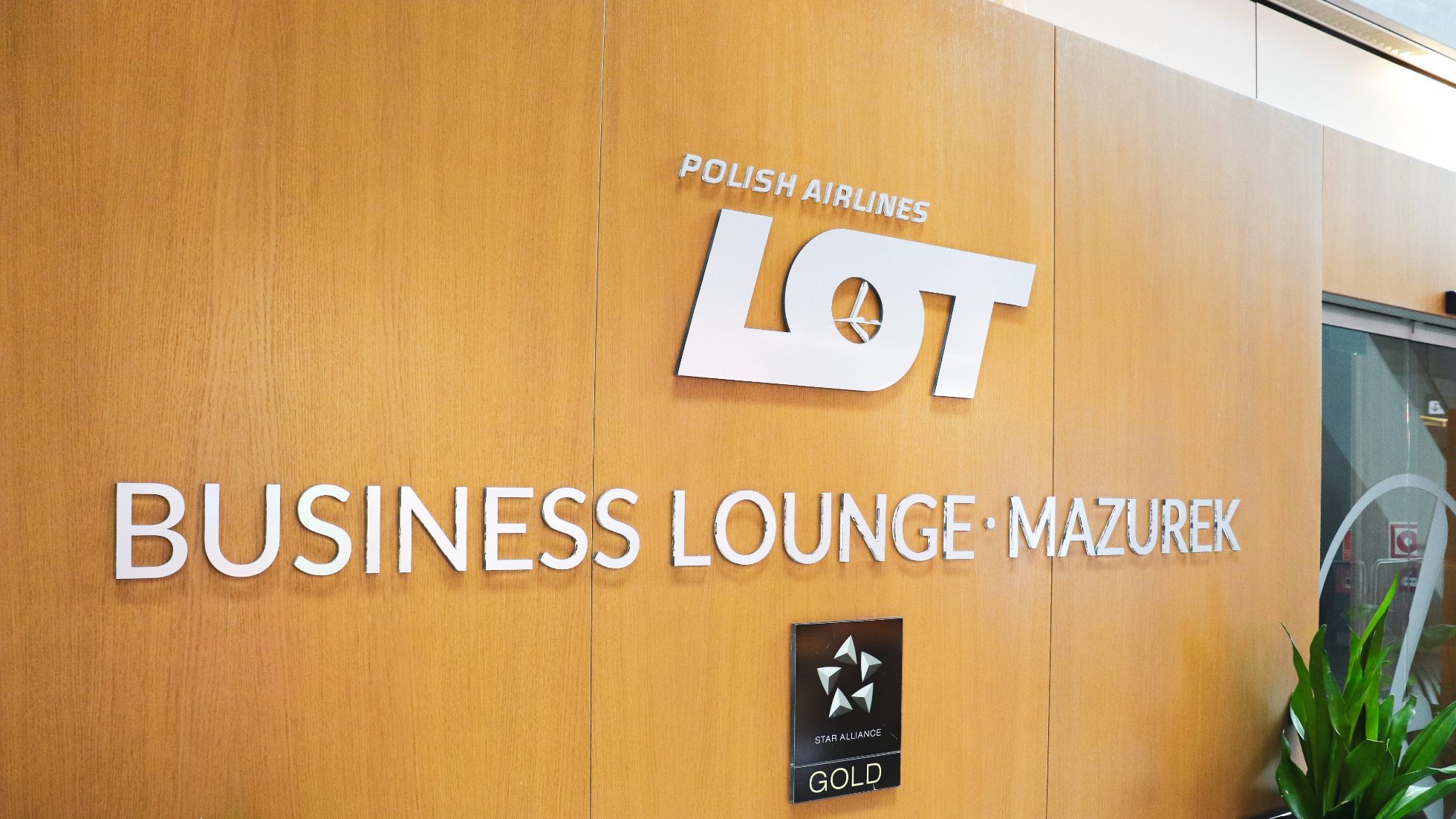Wooden wall with LOT Business Lounge Mazurek logo