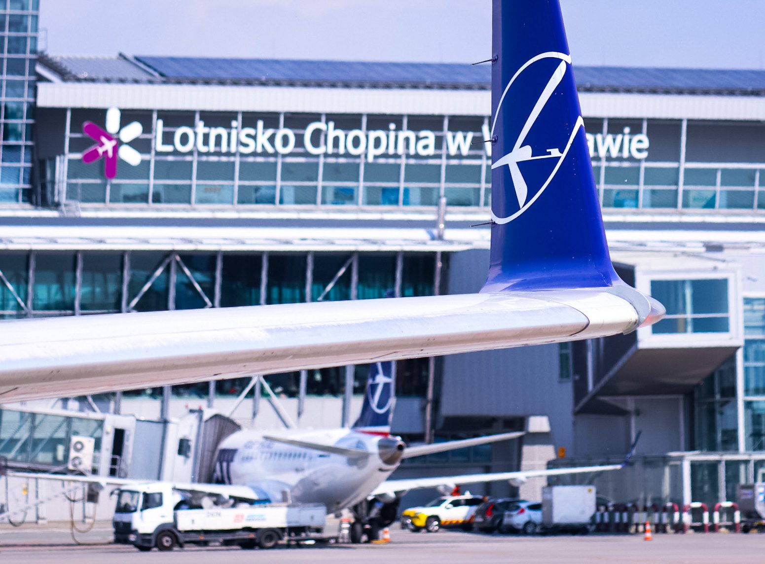 Winglet des Embraer 175 mit dem Terminal des Chopin-Flughafens im Hintergrund