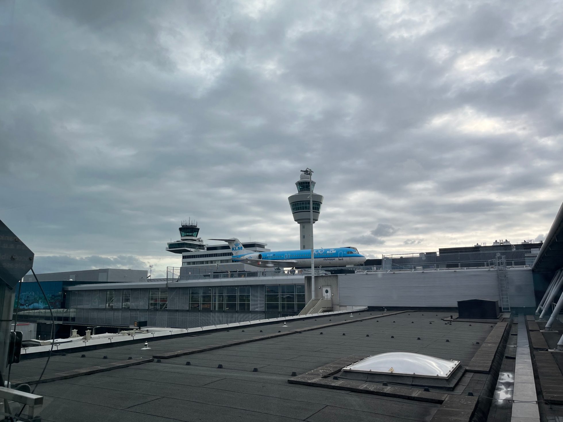 Terminal lotniska z widokiem na pas startowy i samoloty.