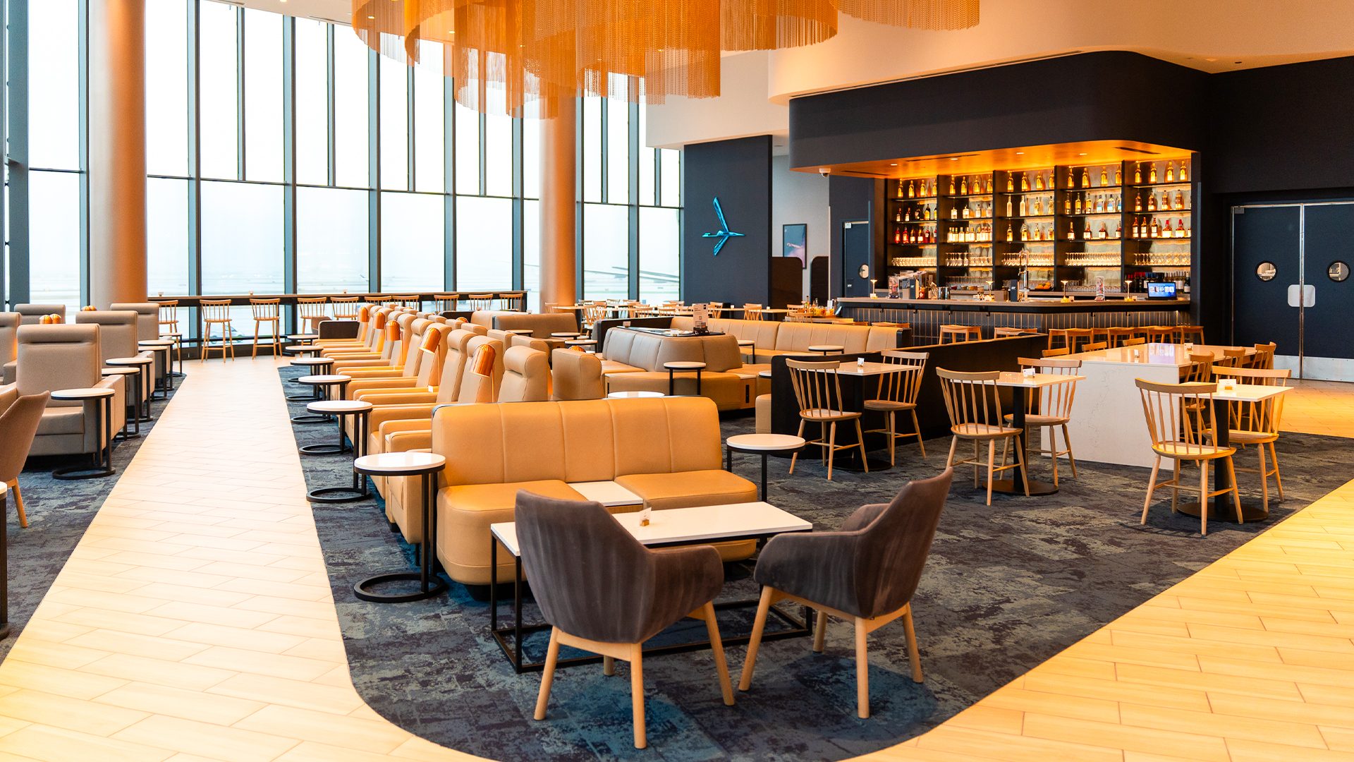 Przestrzeń z kanapami do siedzenia i zdobnym sufitem w LOT Business Lounge w Chicago
