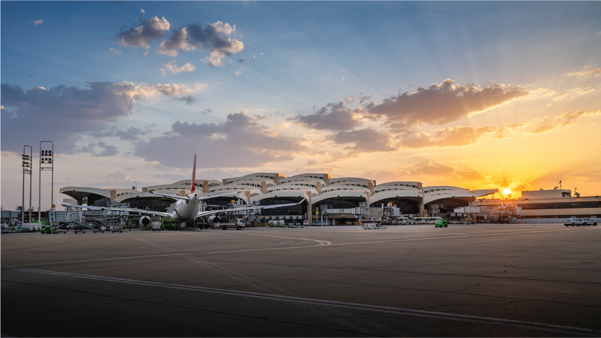 Terminal lotniska w Rijadzie z widokiem na pas startowy i samoloty.