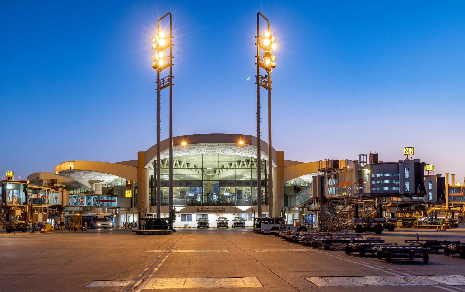 Terminal lotniska w Rijadzie z widokiem na pas startowy i samoloty.