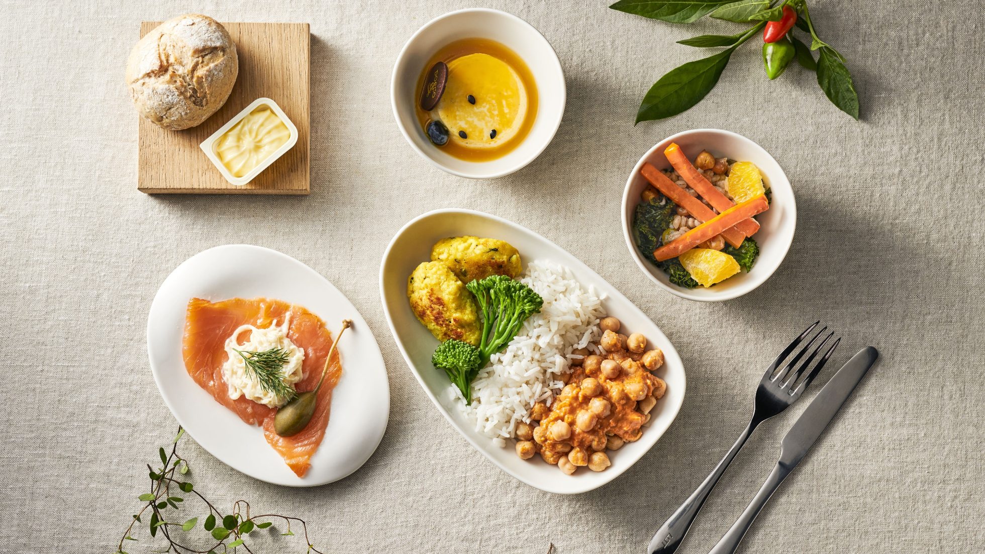 Food on a plate, cutlery, and a mug on a white background.