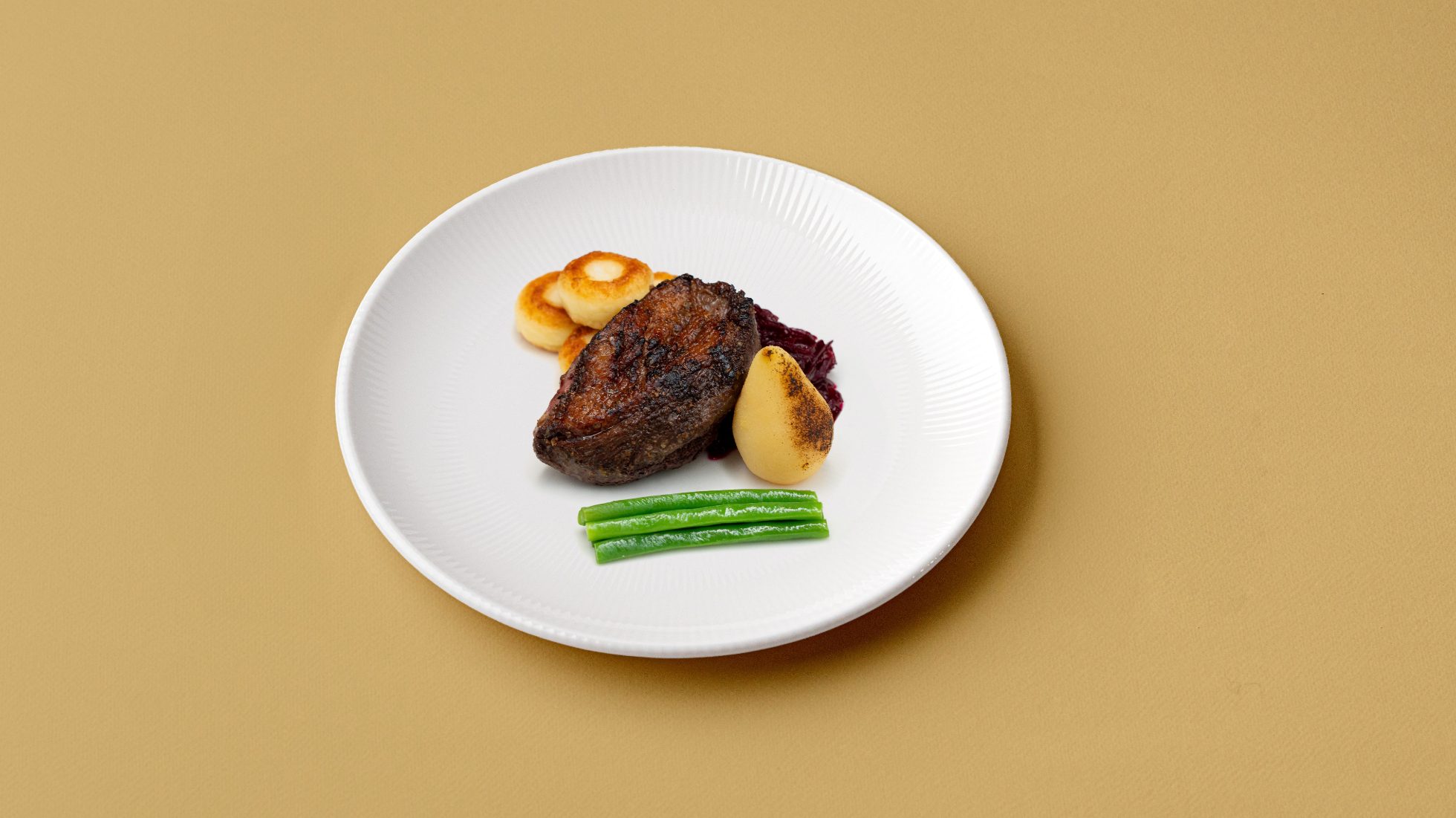 Juicy Polish goose breast served with Silesian dumplings, fried beetroot, green beans, and caramelized pear in sweet syrup.