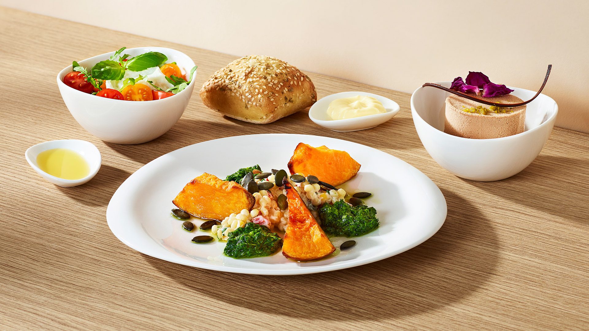 Appetizer consisting of roasted pumpkin with couscous salad and herb mousse. Salad with buffalo mozzarella and tomatoes with arugula. For dessert – chocolate cake with pistachio cream.   