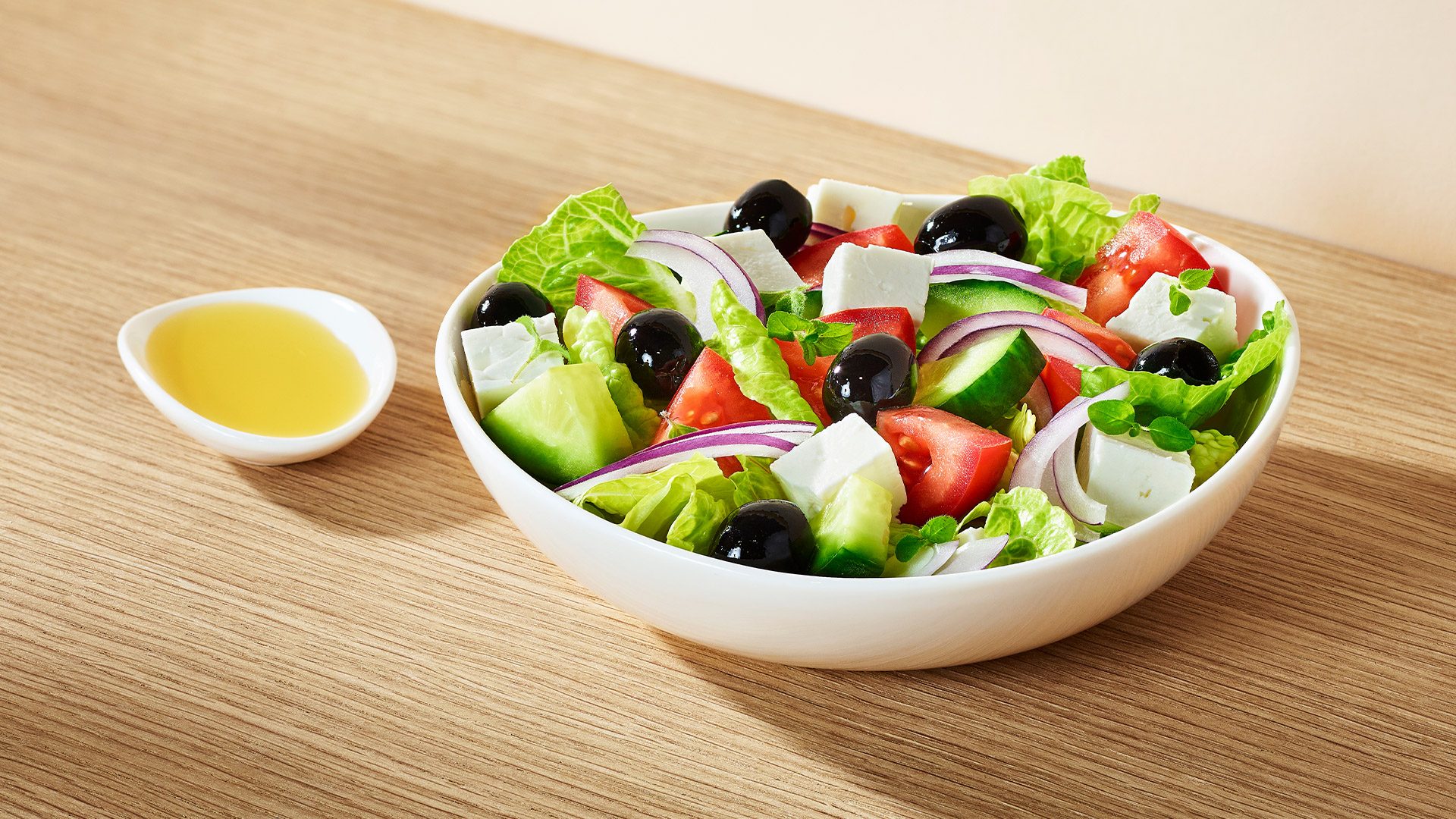 Vegetarian salad – Greek  Fresh romaine lettuce with juicy tomatoes, creamy feta cheese, cucumber, red onion, and black olives, sprinkled with aromatic oregano and extra virgin olive oil. 
