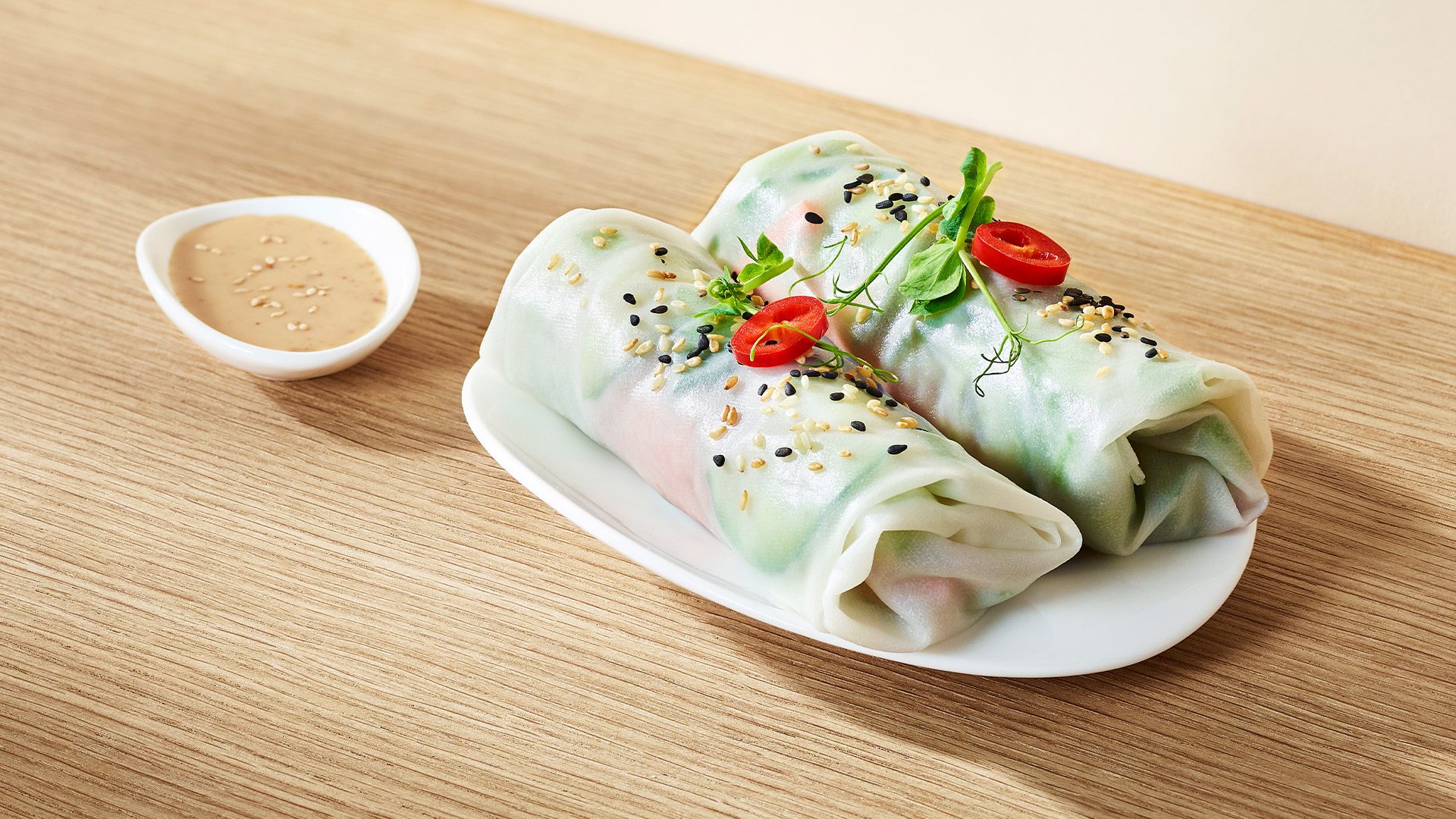 Crispy, delicate spring rolls filled with fresh vegetables, chili peppers, and pea sprouts. Served with an aromatic sesame sauce. 