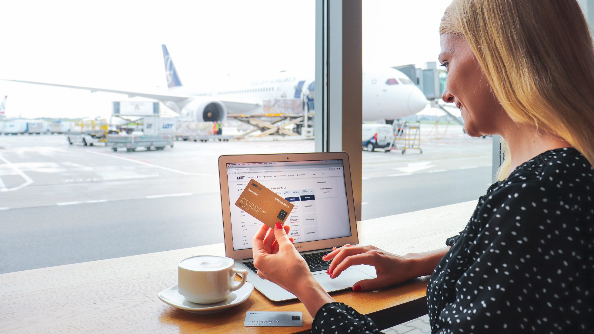 Person holding credit card and passport at airport desk
