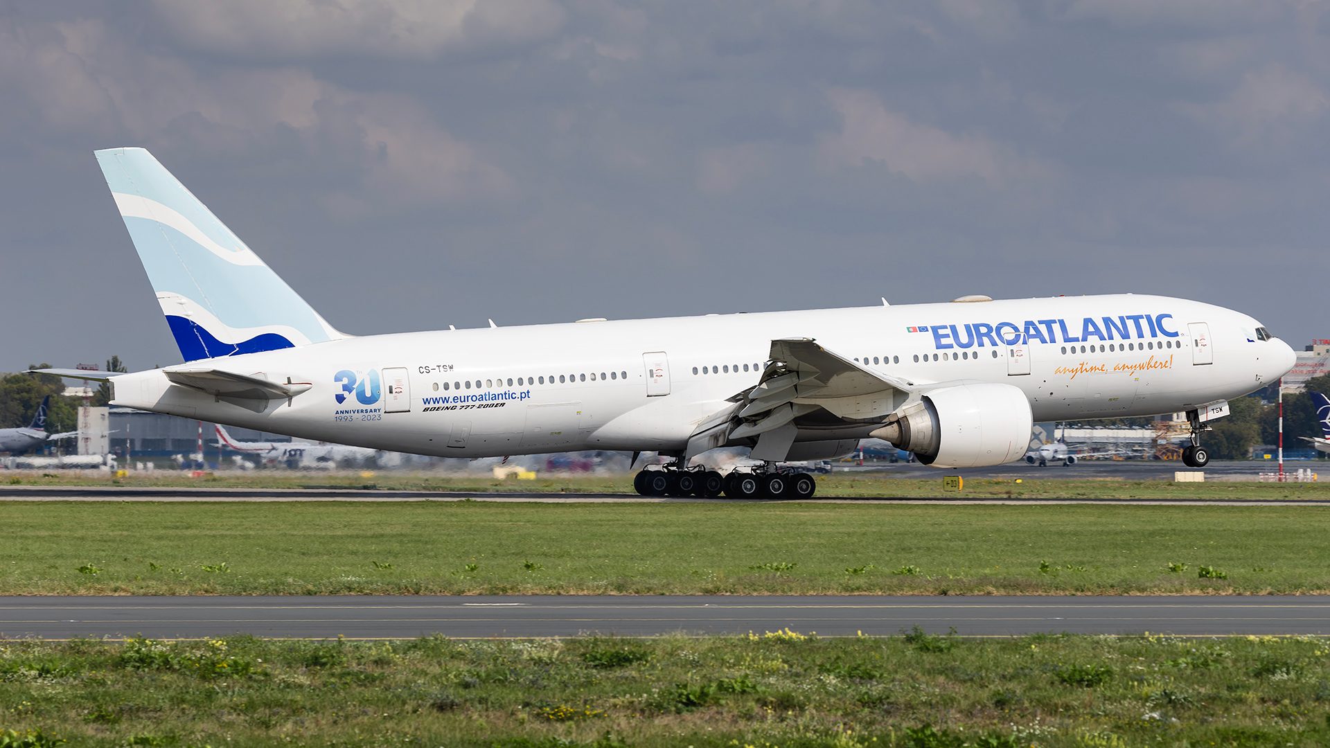 Przybycie Boeinga 777 Euroatlantic, obsługującego LOT, na Lotnisko Chopina w Warszawie w słoneczny dzień.