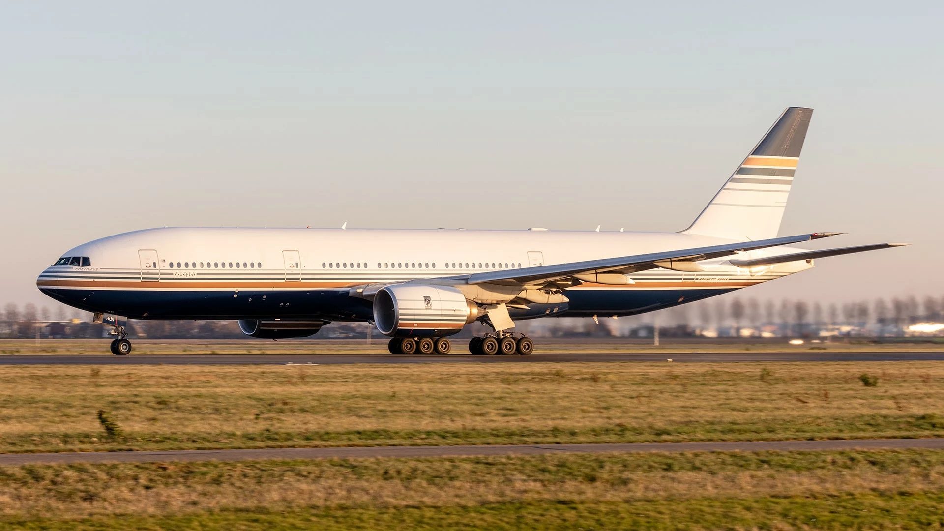 Samolot Boeing 777-200 podczas rozbiegu na pasie o zachodzie słońca