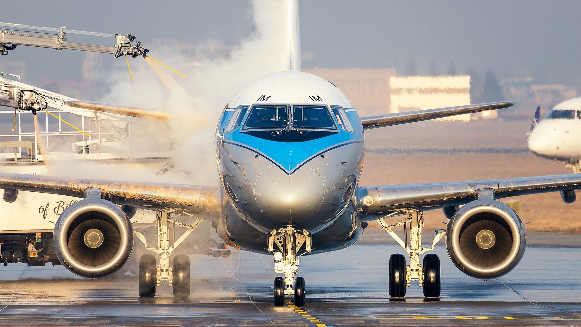 Embraer 175 w malowaniu retro podczas odladzania na Lotnisku Chopina