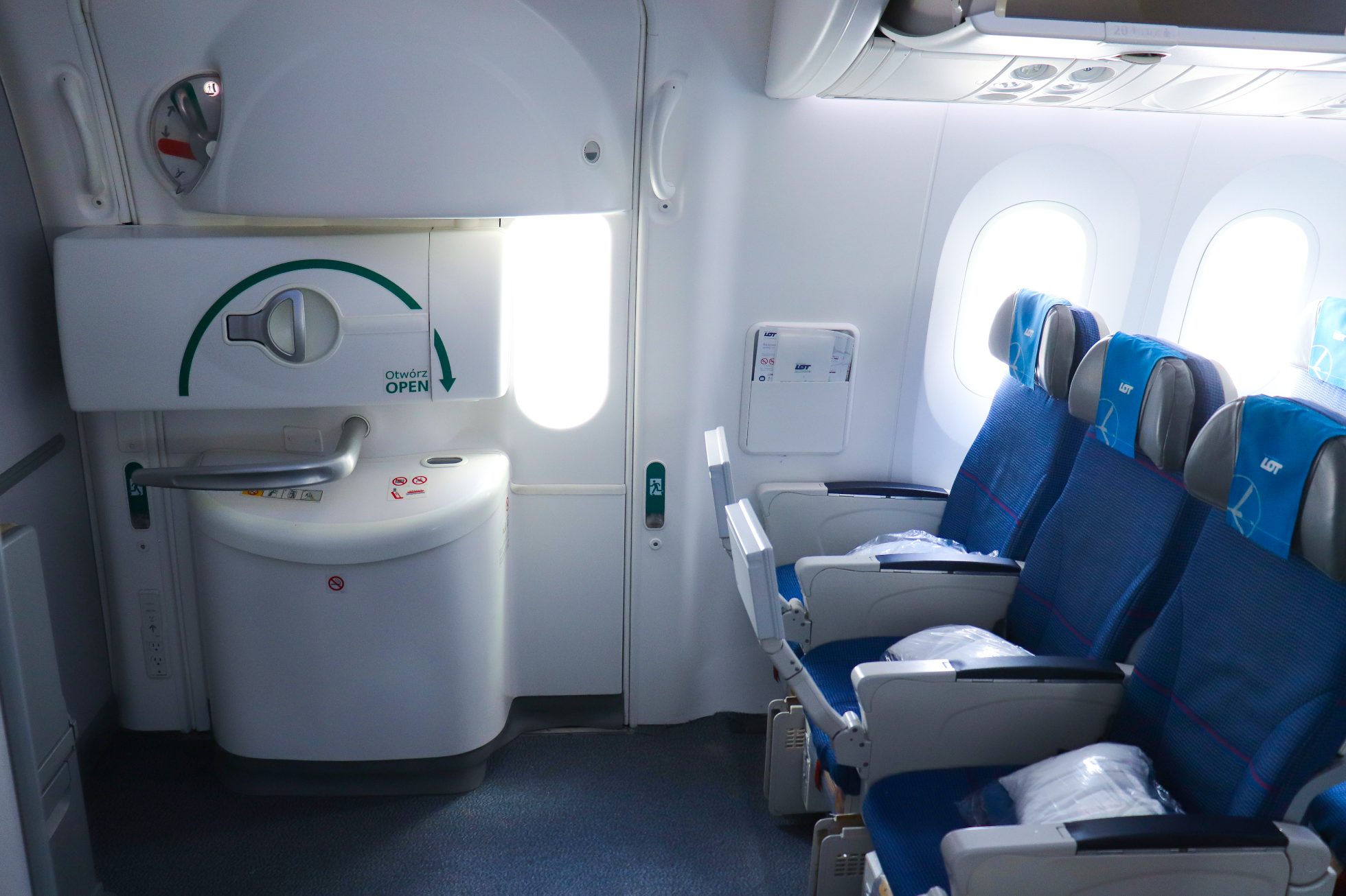 Passenger plane interior with comfortable seats and lighting.