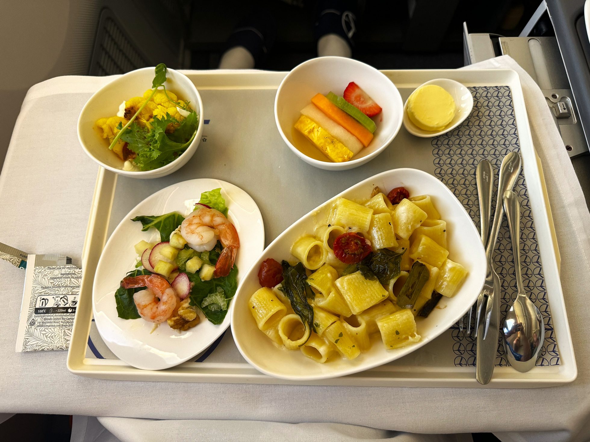 Posiłek w klasie biznesowej LOT Polish Airlines na pokładzie samolotu 787 - makaron z serem, sałatka z krewetek i owoce.