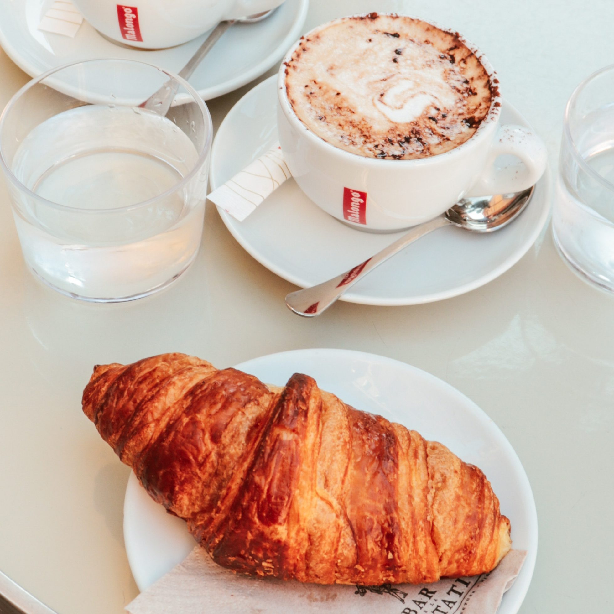 Croissant i kawa na białym stoliku