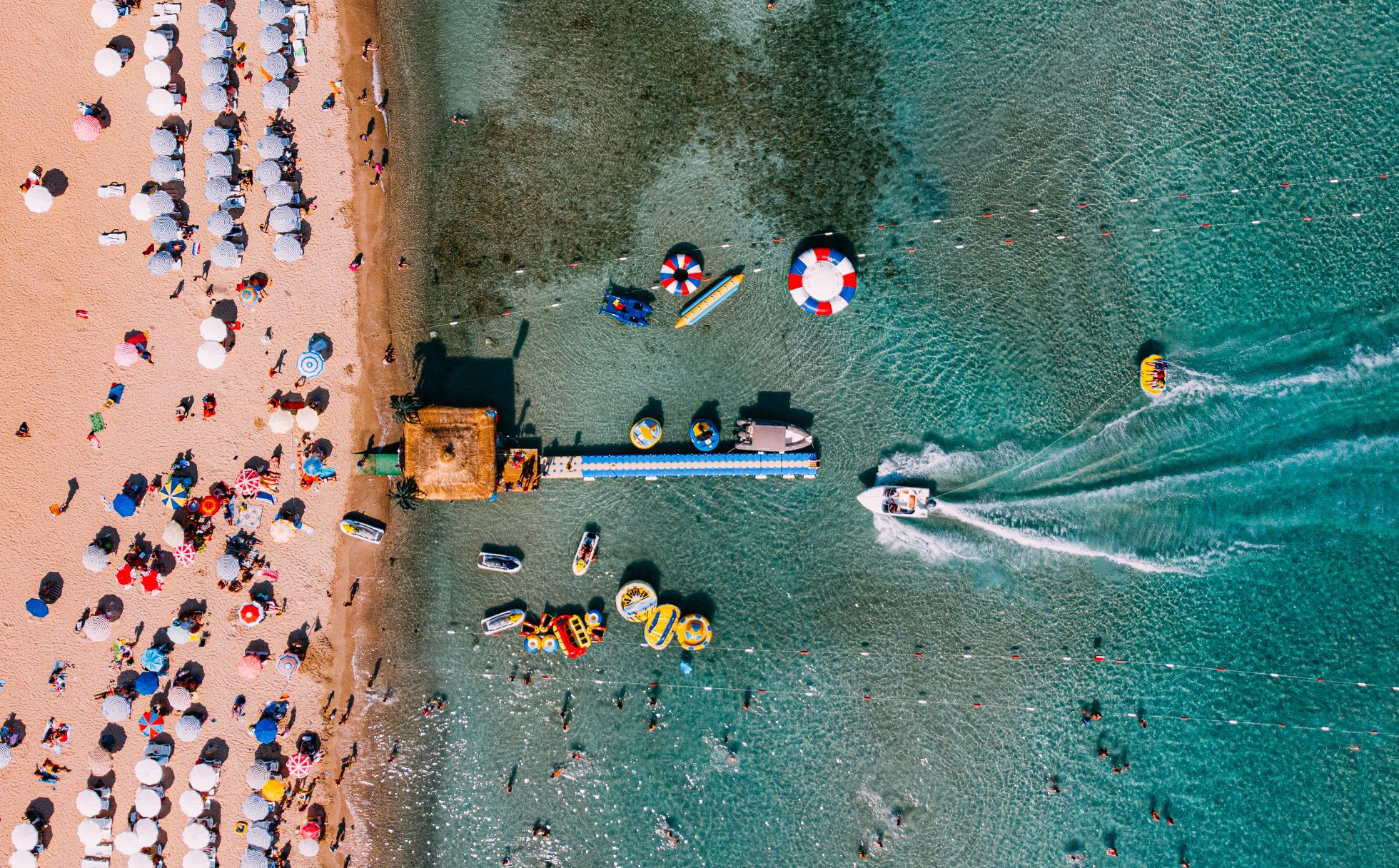 Piaszczysta plaża nad morzem w Turcji. Słońce, błękitne niebo, turkusowa woda.