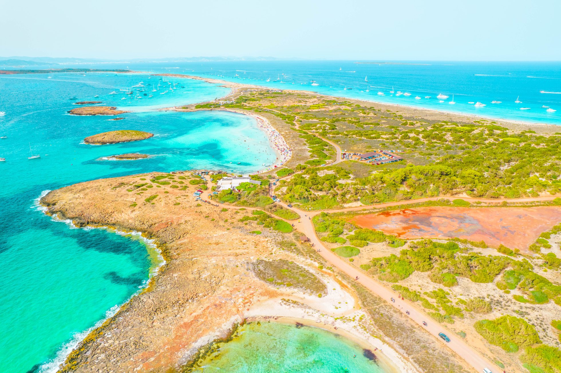 Piaszczysta plaża z turkusową wodą i niebieskim niebem na wyspie Formentera.