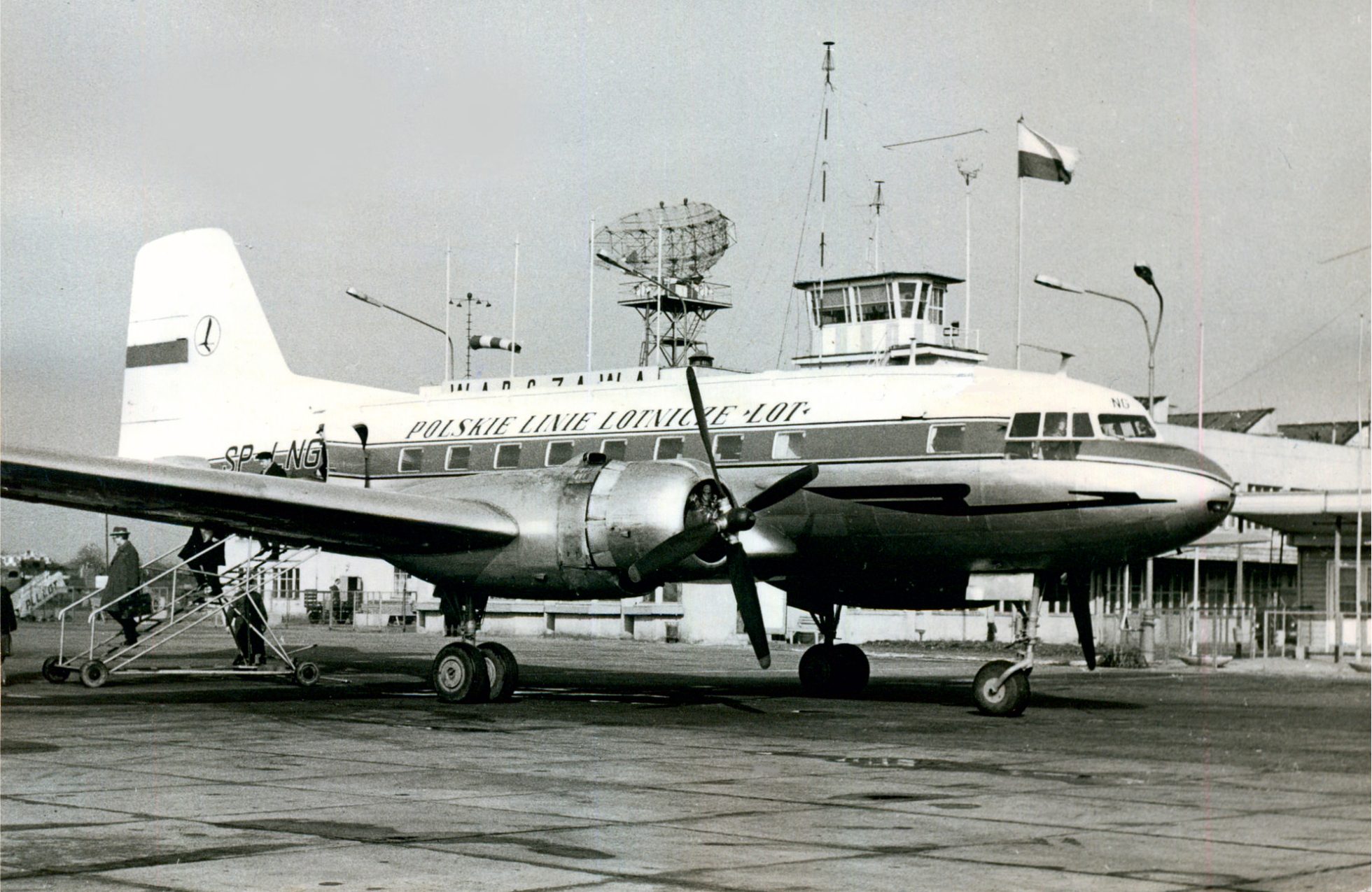 A black and white photo of a LOT airplane in Warsaw.